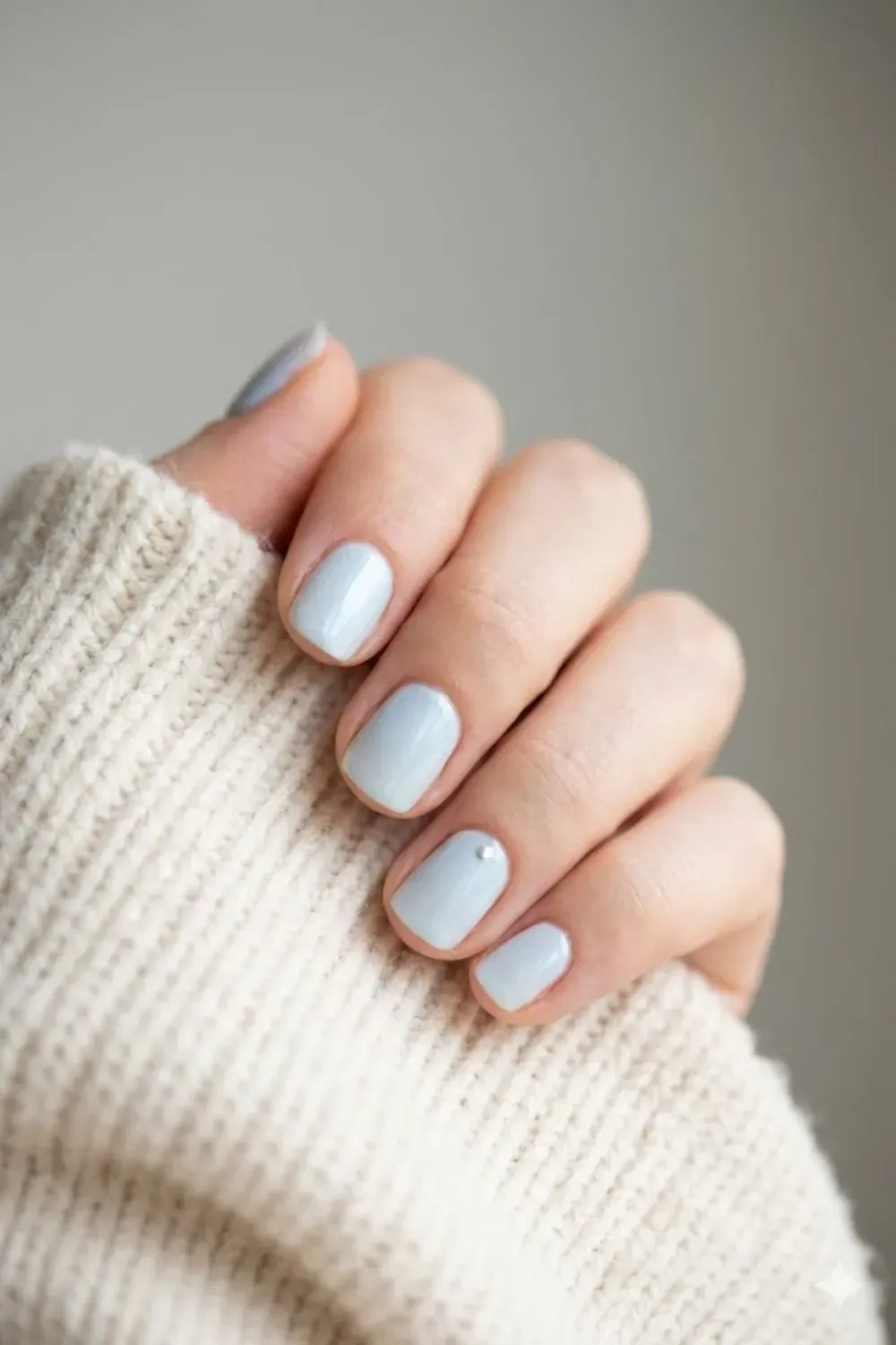 Short Square Icy Shimmer Nails with Pearl Accent – Short square light icy blue nails with a subtle shimmer and a single small pearl accent at the cuticle