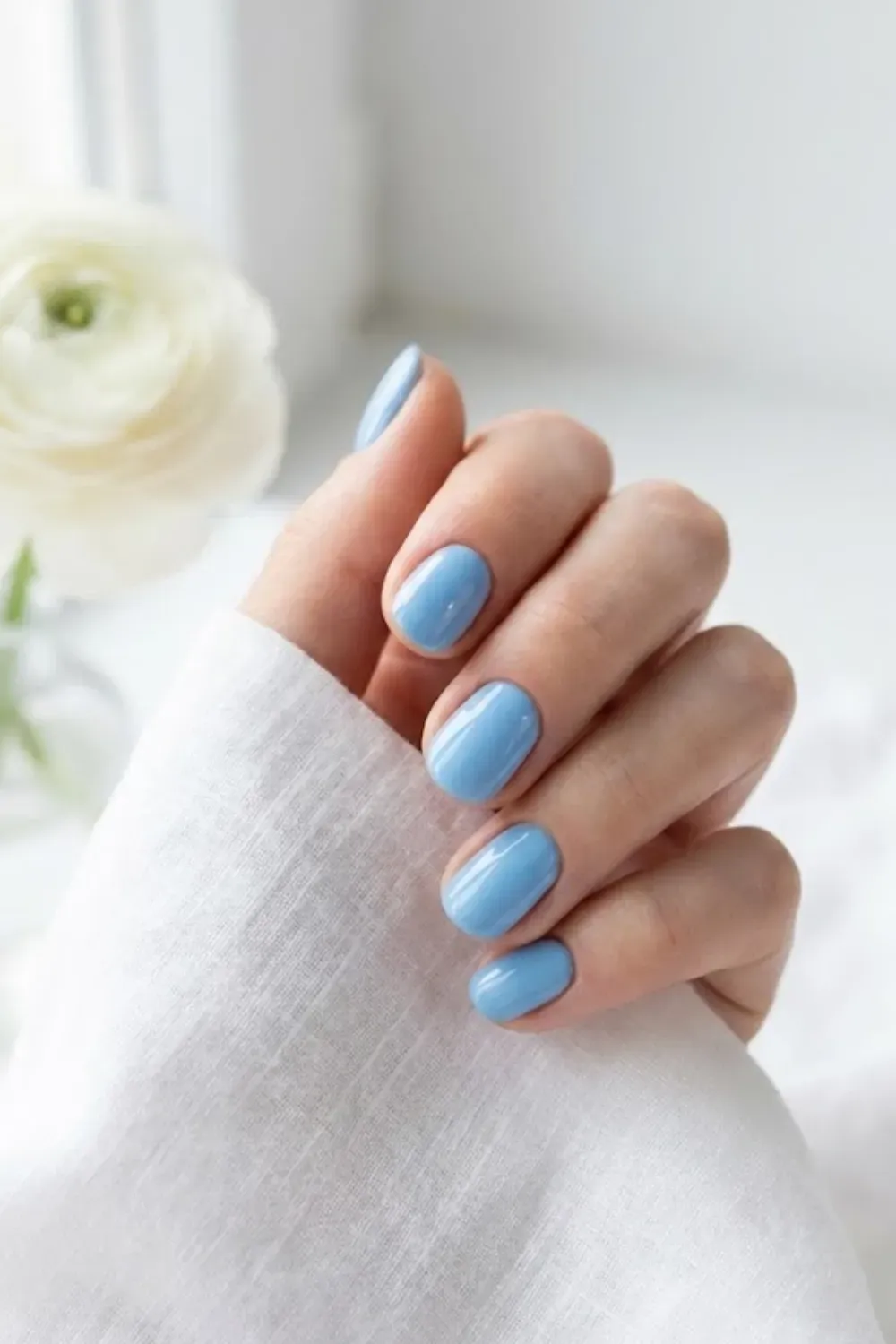 Glossy sky blue nails, a slightly deeper pastel blue tone.