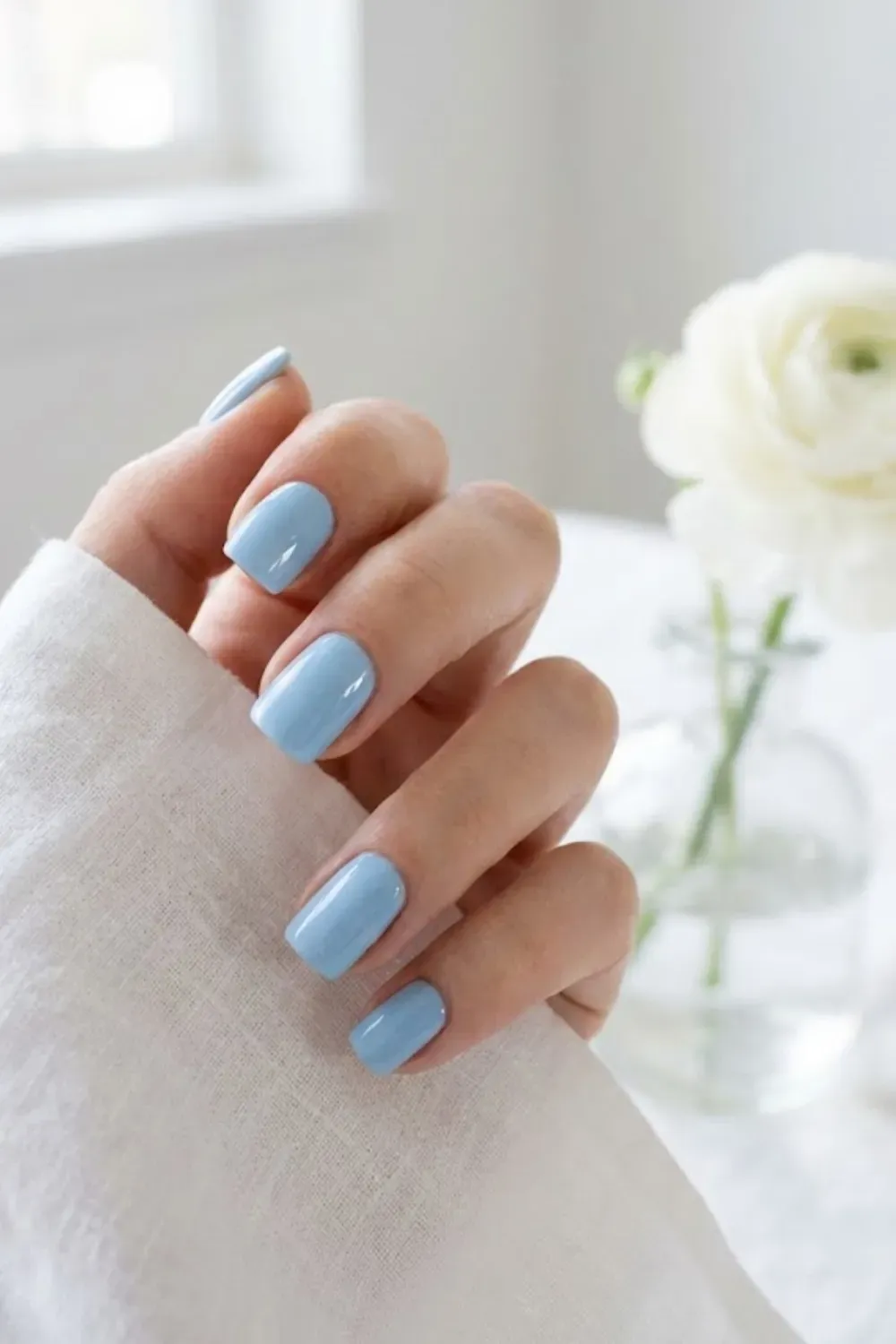Clean baby blue manicure on short square nails, soft and airy spring aesthetic.