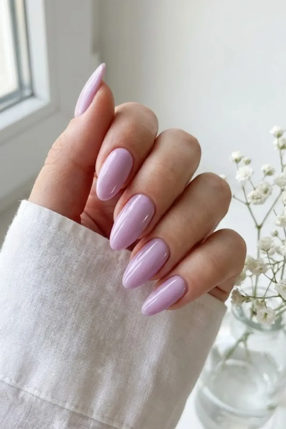 Long almond nails in a glossy lavender purple.