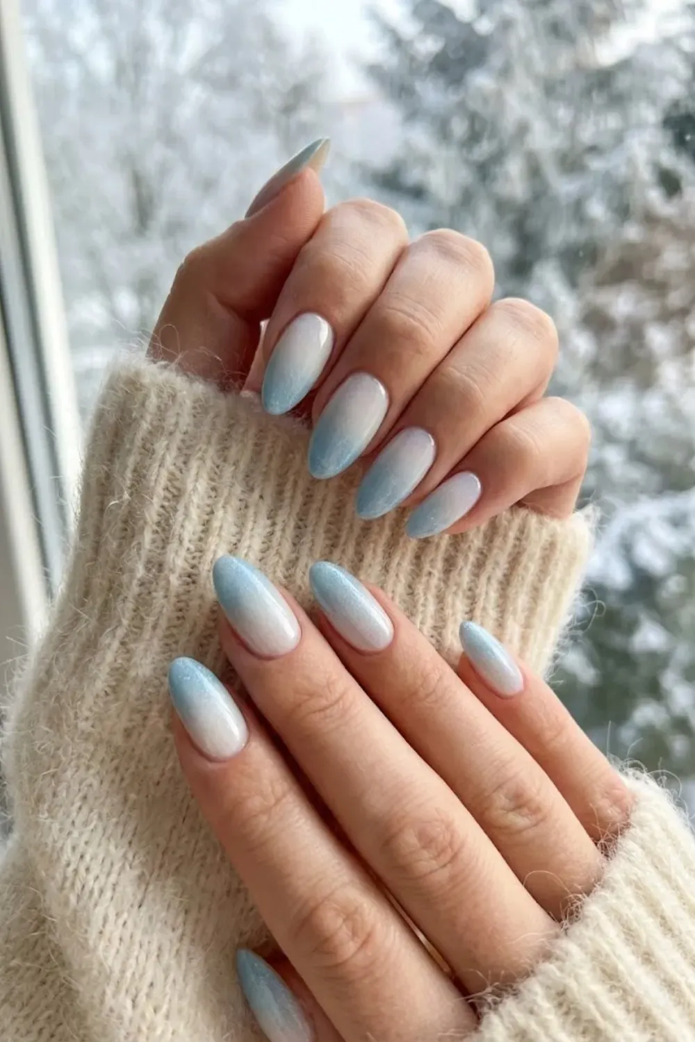 Frosty Blue and White Ombre Almond Nails – Almond nails featuring a winter ombre gradient from white to icy blue with a sugar glitter finish.