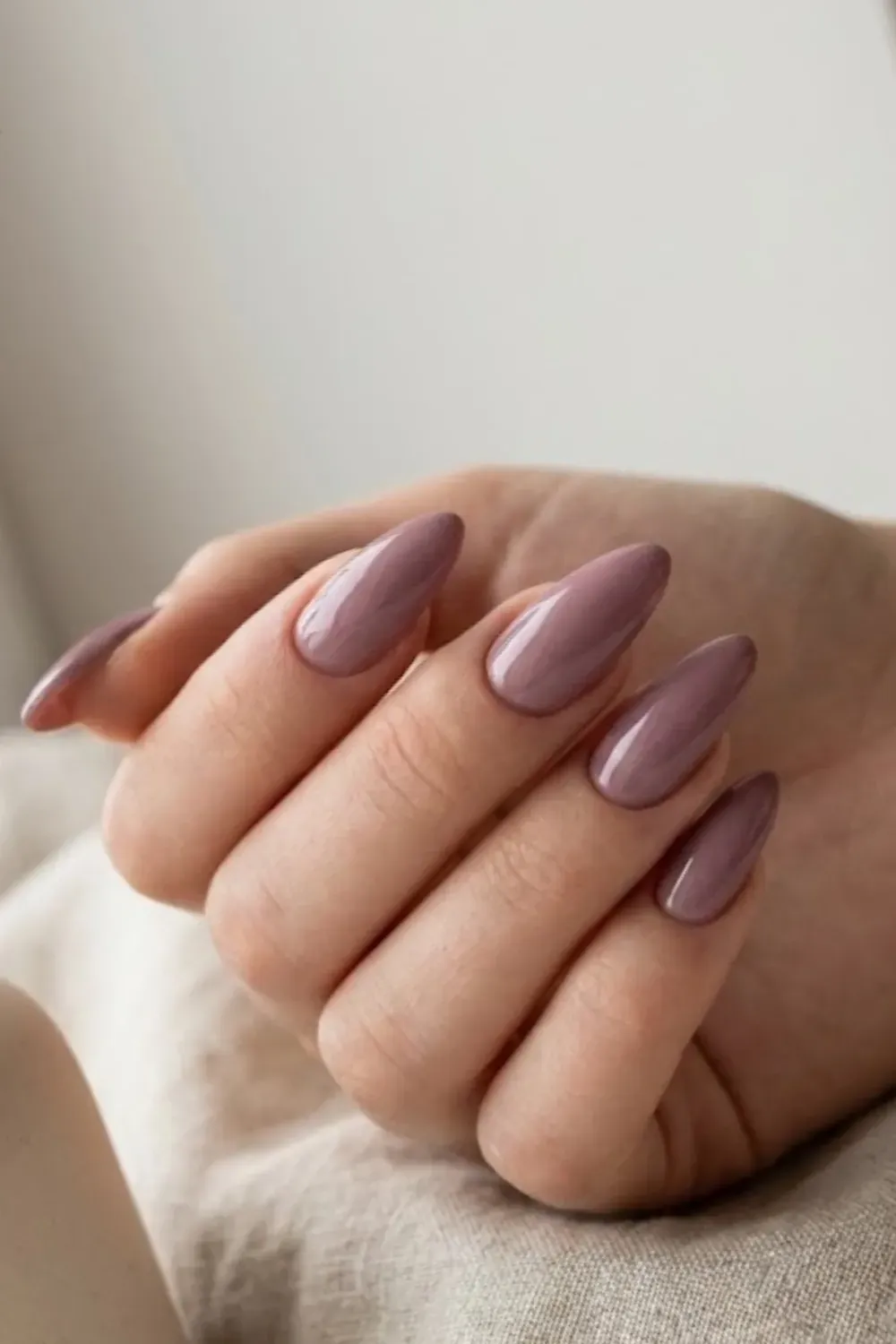 Elegant almond nails in a dusty mauve pink, moody but soft spring color.