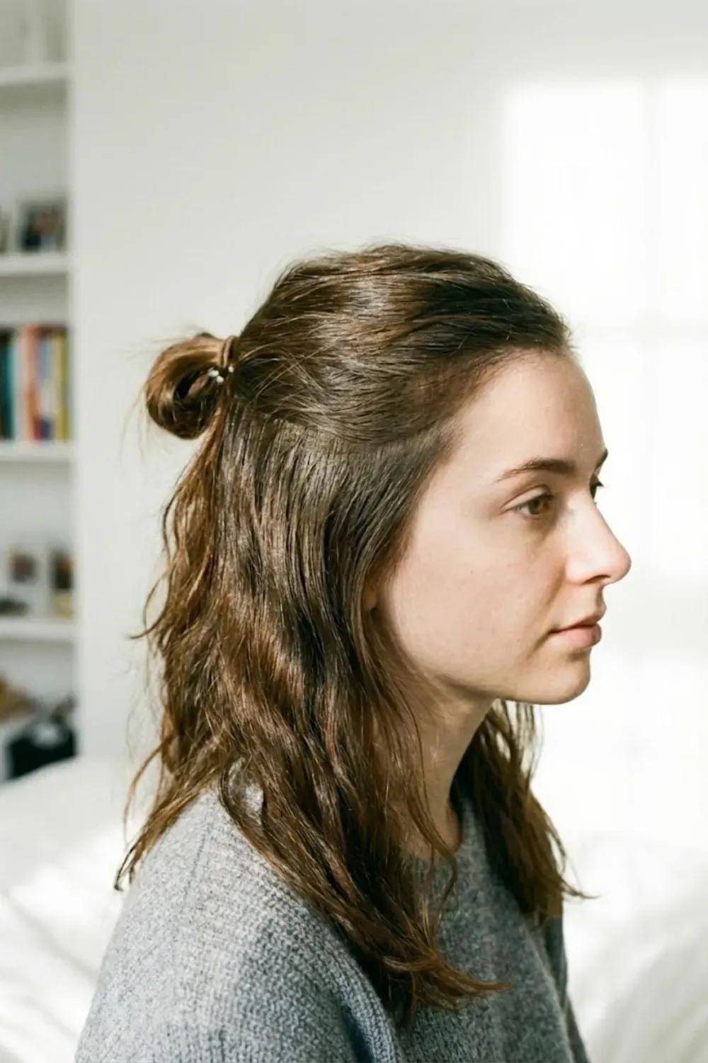 Messy Half-Up Top Knot - Side view of a half-up half-down hairstyle with a small messy bun on top
