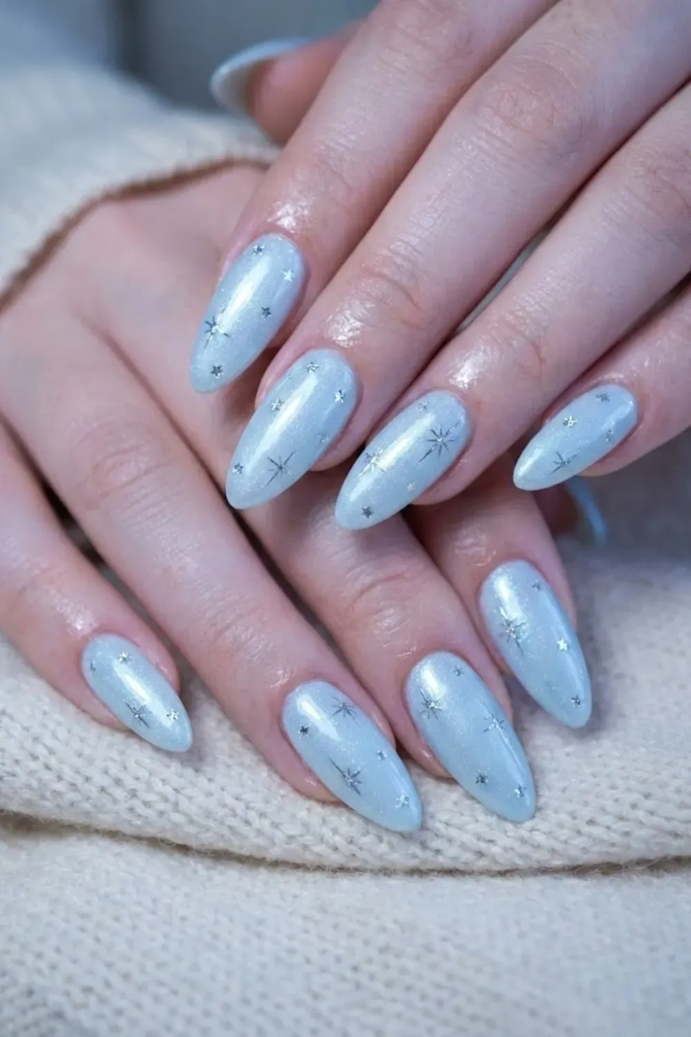 Sparkling Icy Blue Nails with Star Details – Almond nails with a light blue shimmery base and hand-painted silver stars or sparkles, giving a magical winter vibe.