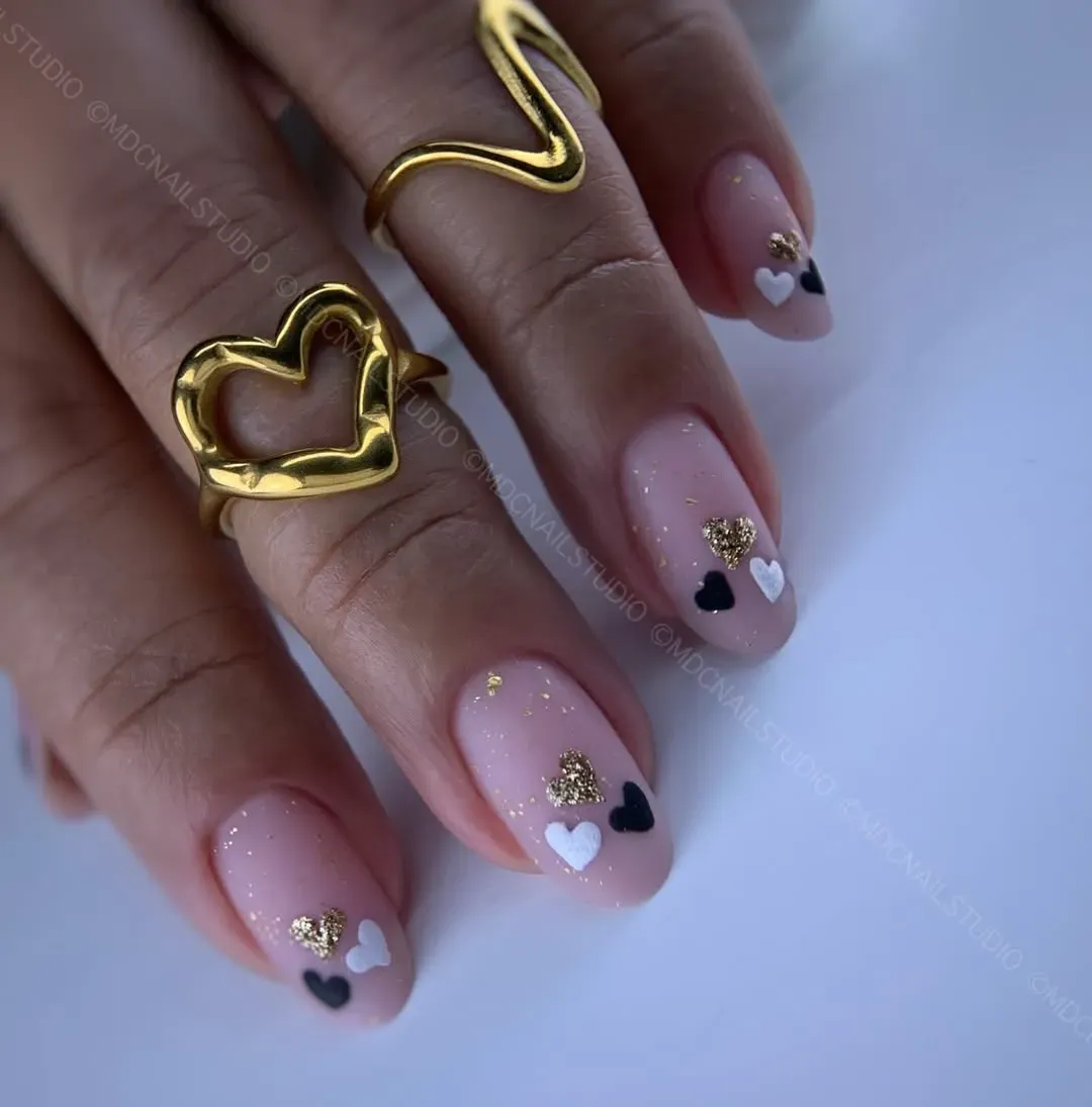 Soft Pink Valentine Nails with Tiny Black and White Heart Details and Gold Flecks