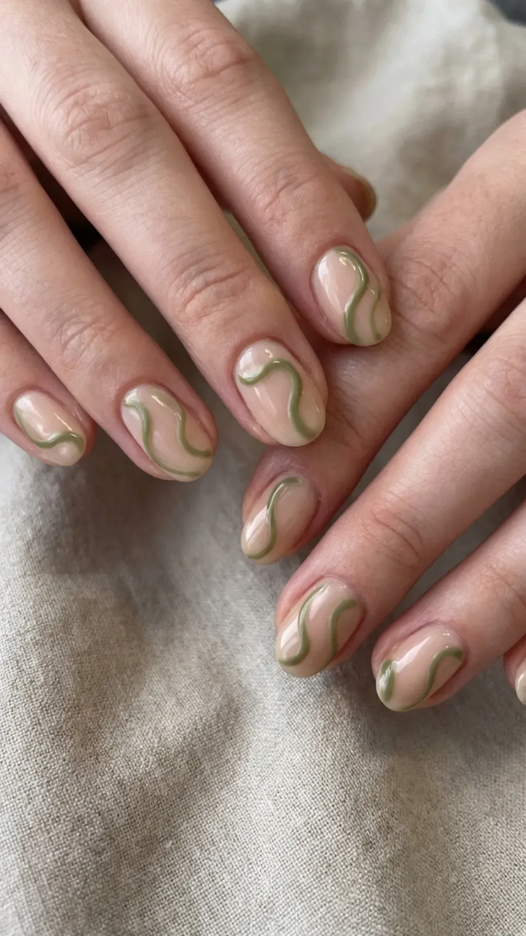 Olive green swirl nail art on nude base abstract style