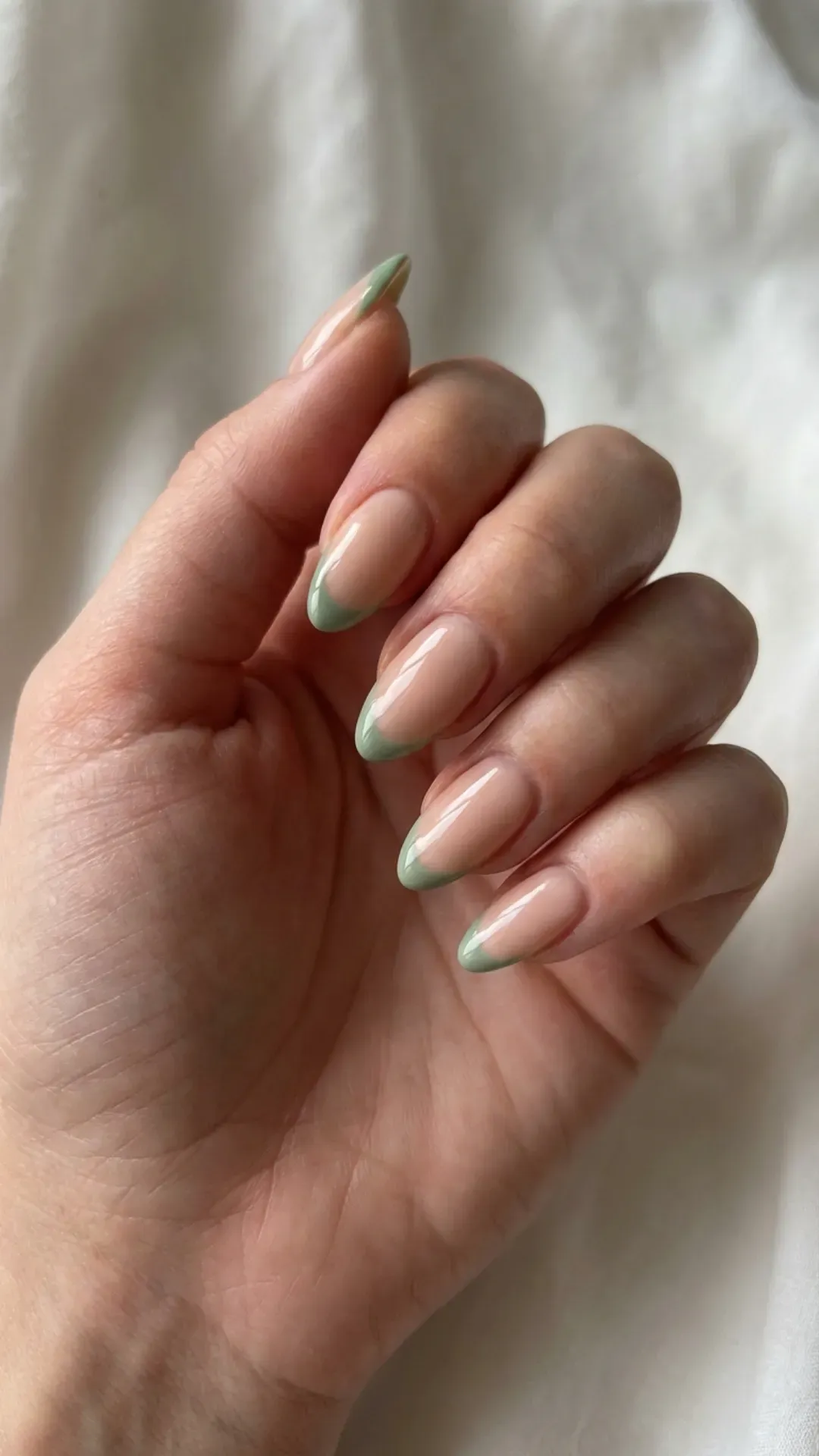  Nude almond nails with sage green French tips glossy finish