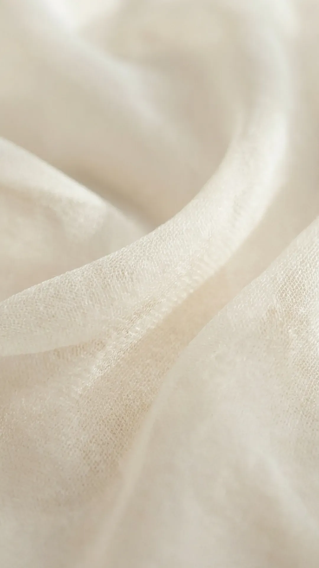 Neutral clothing and soft fabric textures arranged simply, highlighting how calm materials contribute to effortless elegance