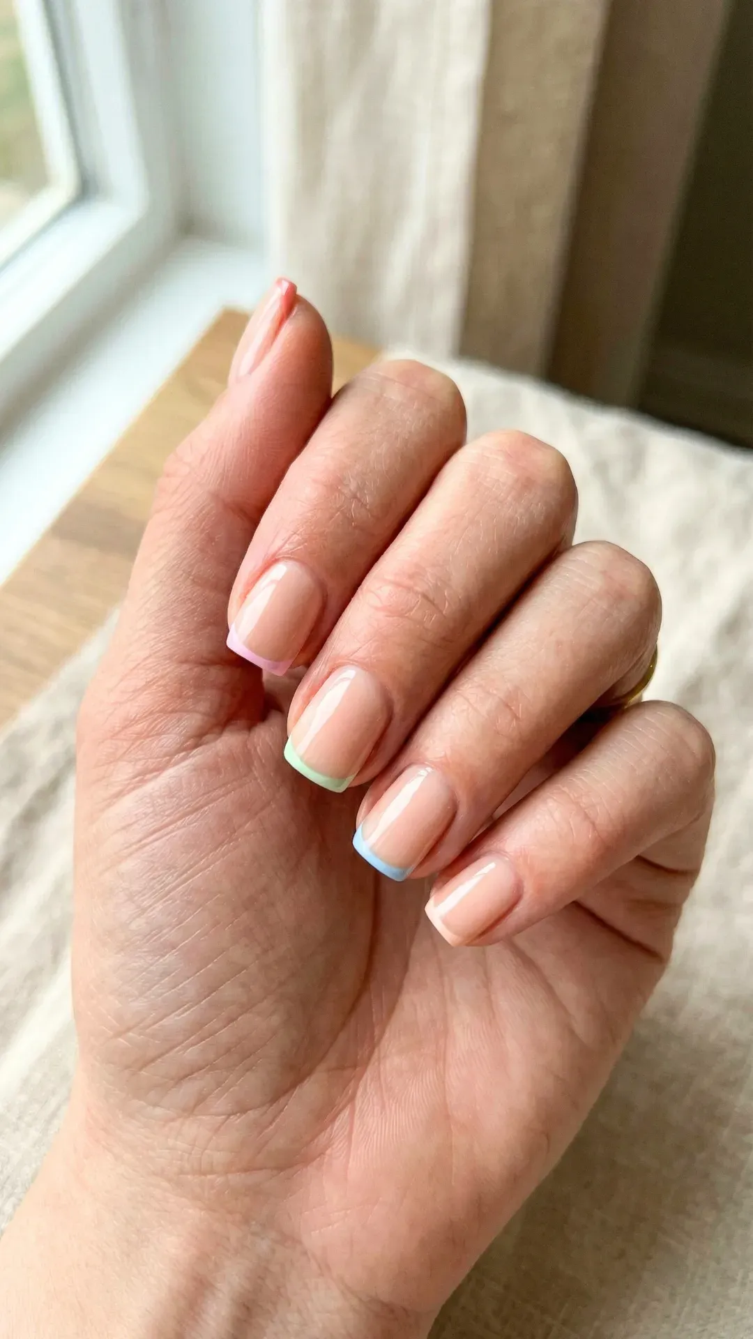 Minimalist micro French tip nails with pastel colored tips on short square nude manicure — clean nail trend 202