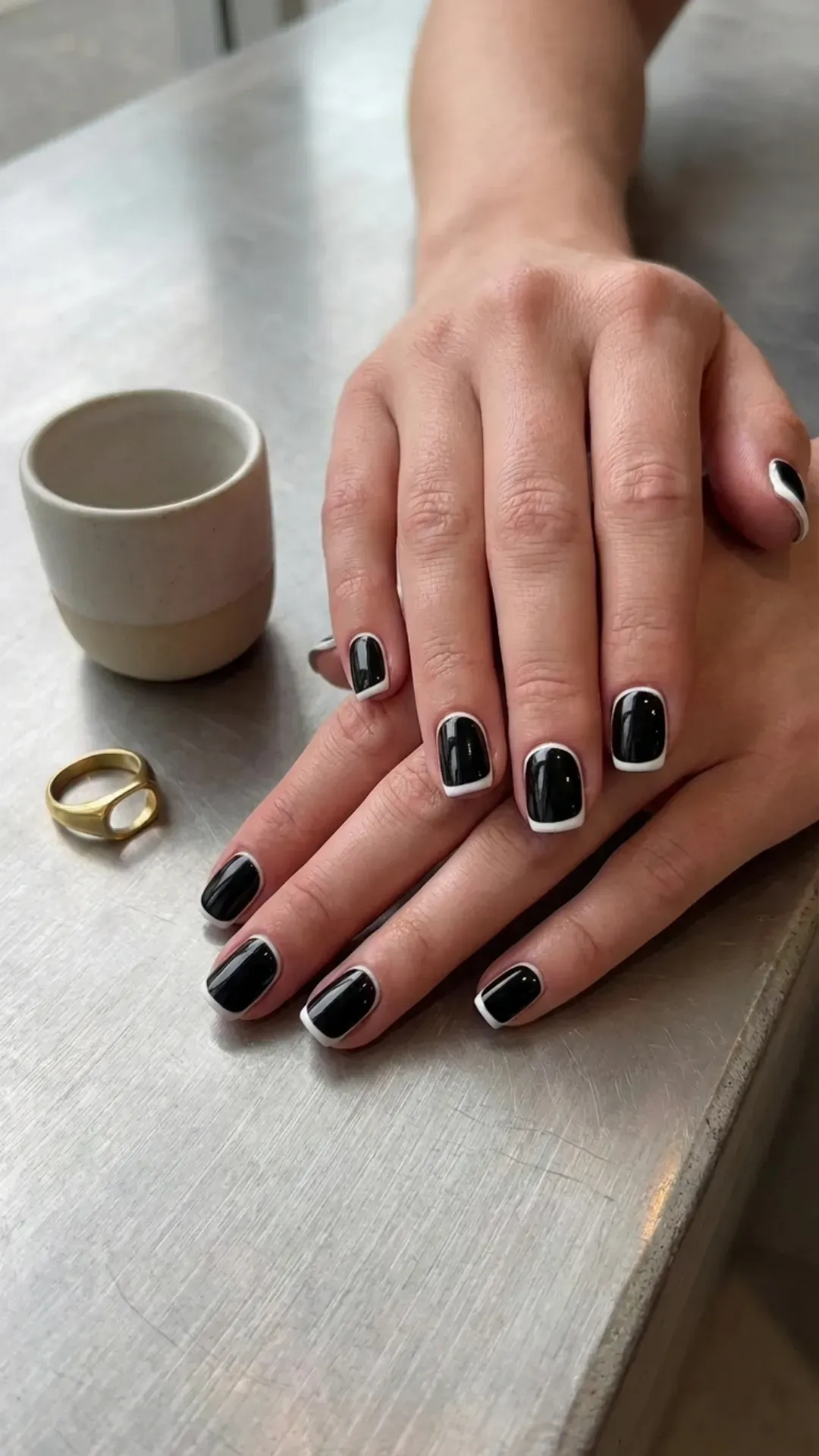 Chic black nails with a stark white outline, offering a modern and minimalist luxury look with a graphic twist.