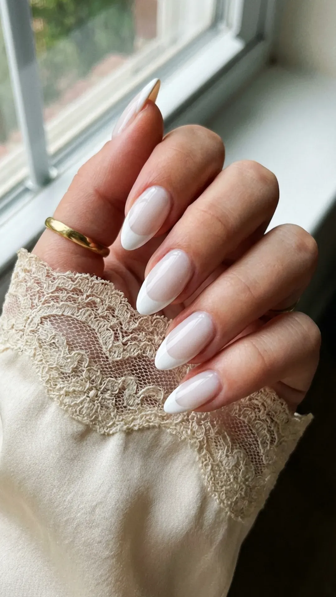 Classic milky white almond French tip nails with a glossy finish for a timeless and refined appearance.