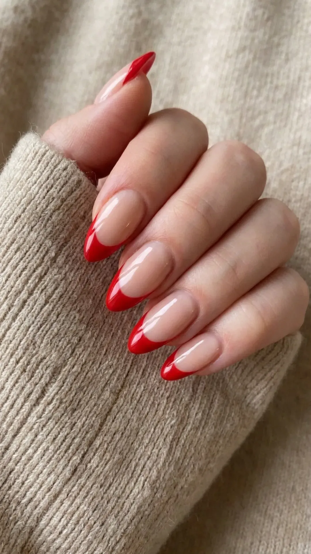 Vibrant red almond French tip nails offering a striking and glamorous look for any special occasion.