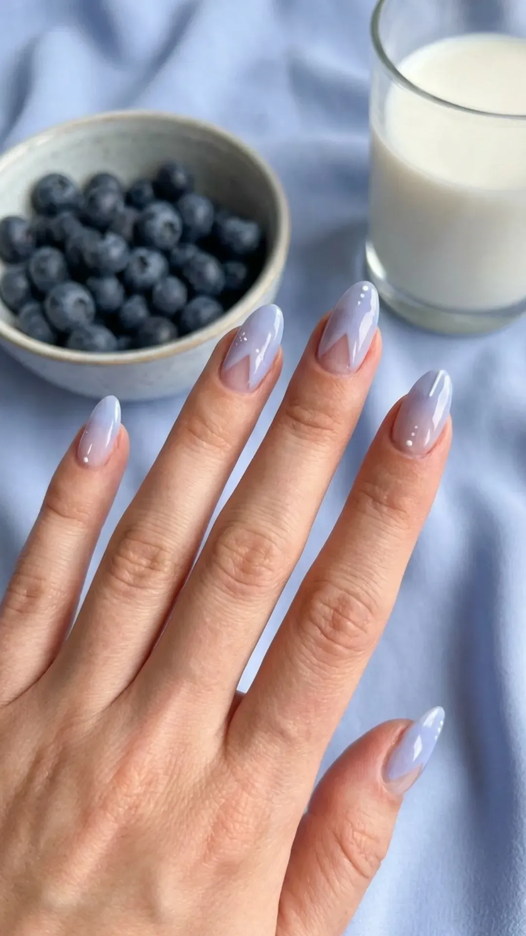 Modern blueberry milk negative space nails featuring minimalist designs against a pastel blue backdrop
