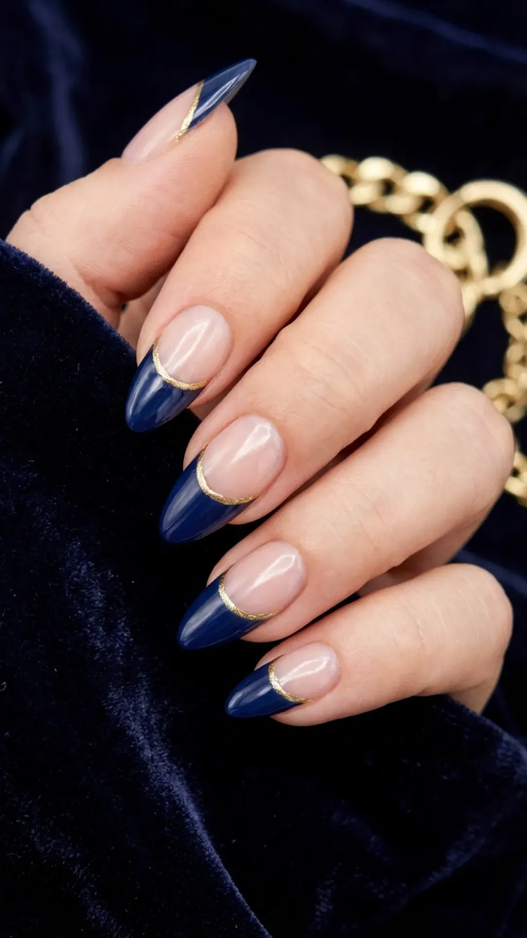 Sophisticated navy blue almond nails with elegant gold accents, perfect for a luxurious and stylish statement.