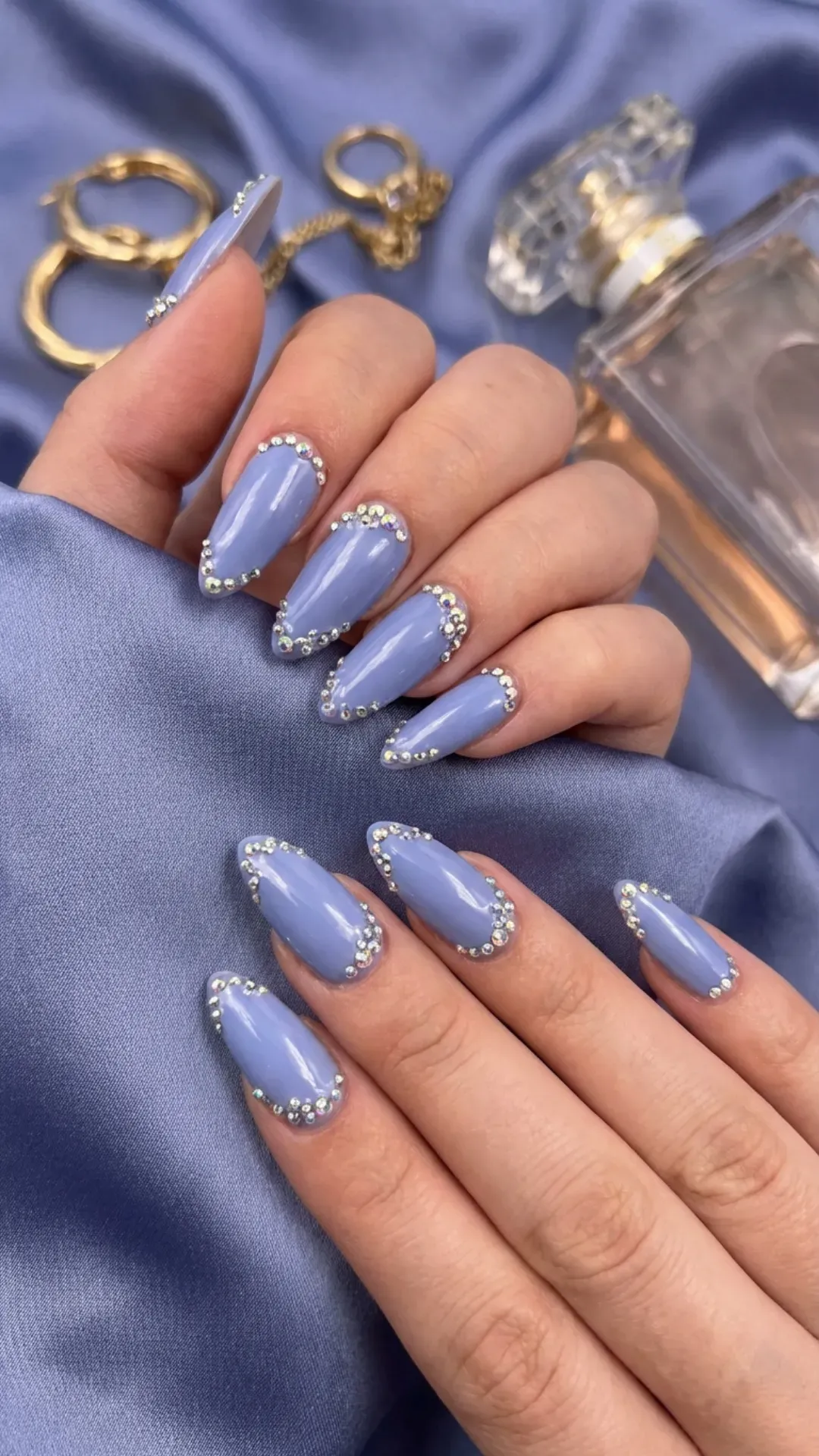 Luxurious blueberry milk-colored nails with rhinestone embellishments adding a touch of glamour to each fingertip