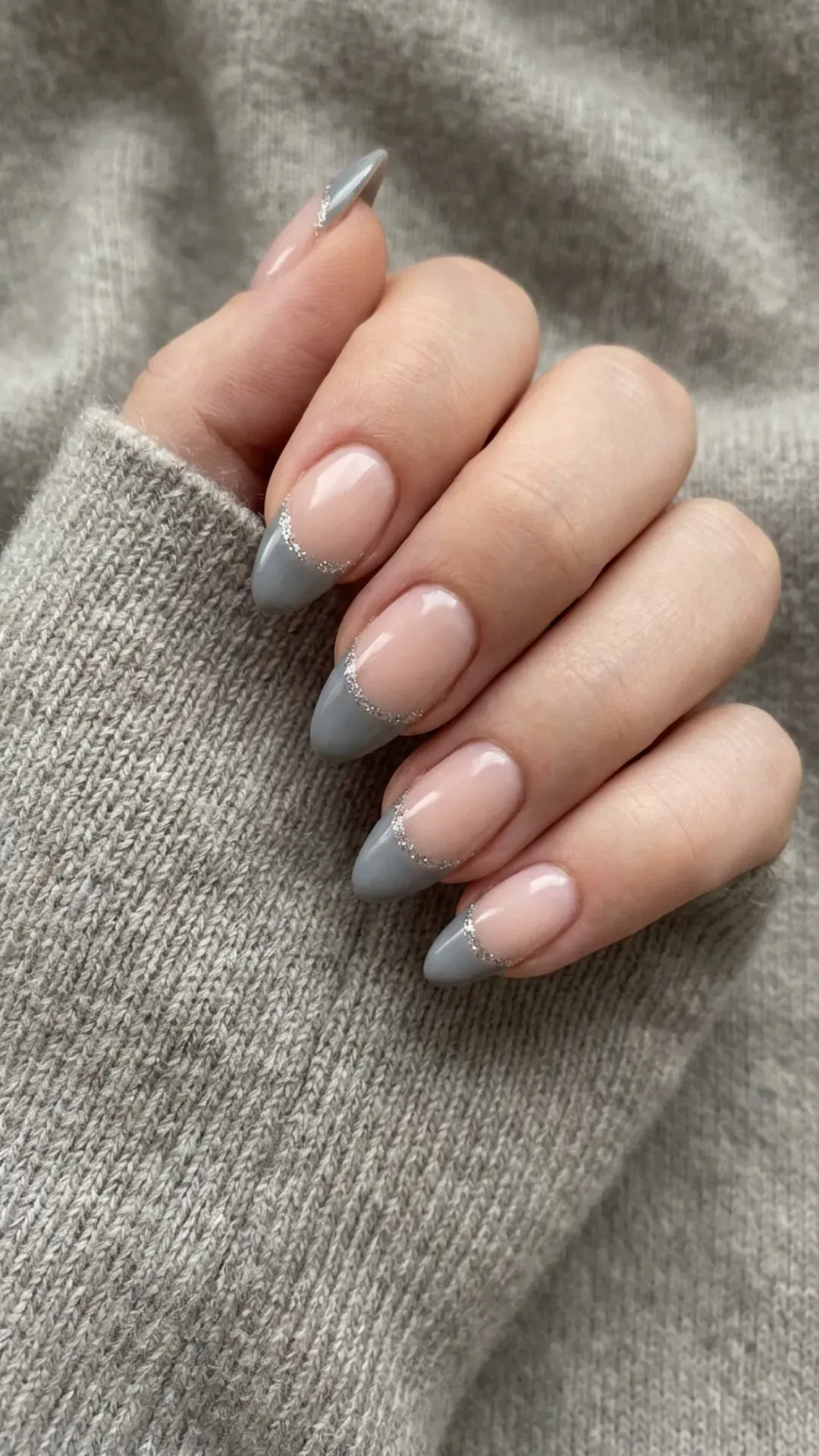 Chic grey almond French tip nails with a touch of silver sparkle, perfect for adding a hint of shimmer to your style.