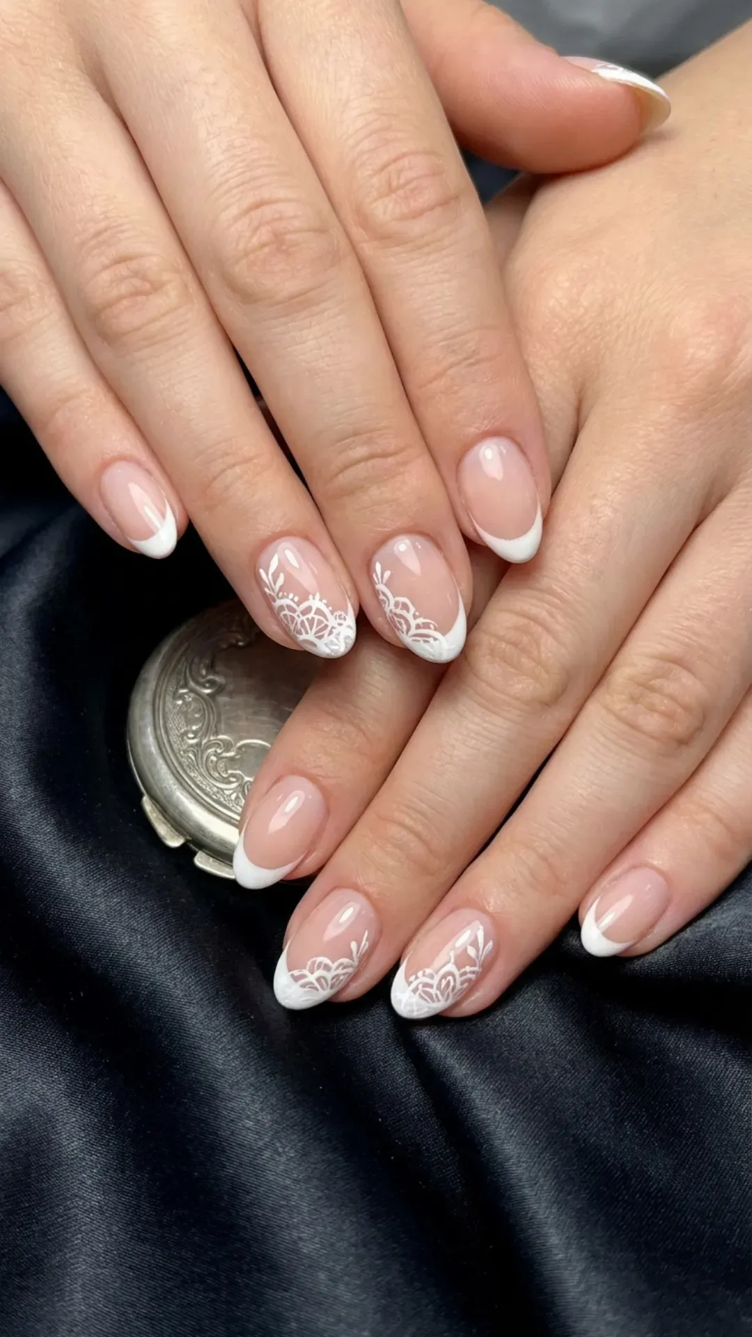 Elegant short nails with intricate white lace patterns on French tips, offering a sophisticated and timeless look suitable for any formal event.