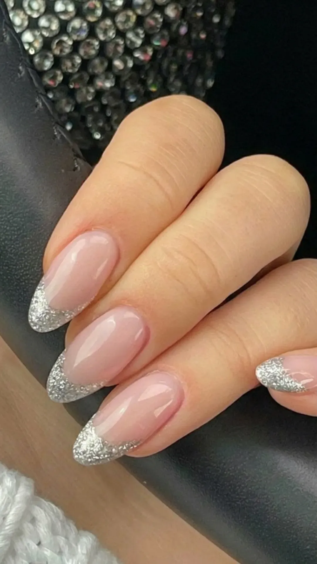 Almond French tip nails with a silver glitter gradient, creating a dazzling effect that transitions beautifully from base to tip.