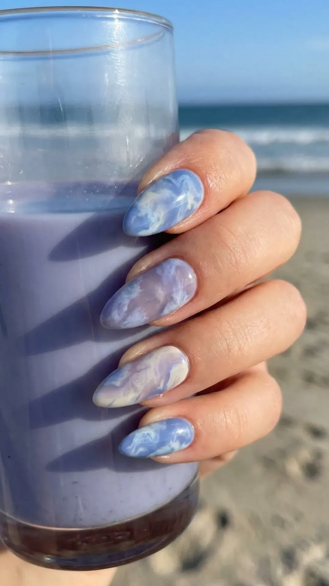 Trendy blueberry milk tie-dye nails with swirling patterns reminiscent of summer skies and ocean waves