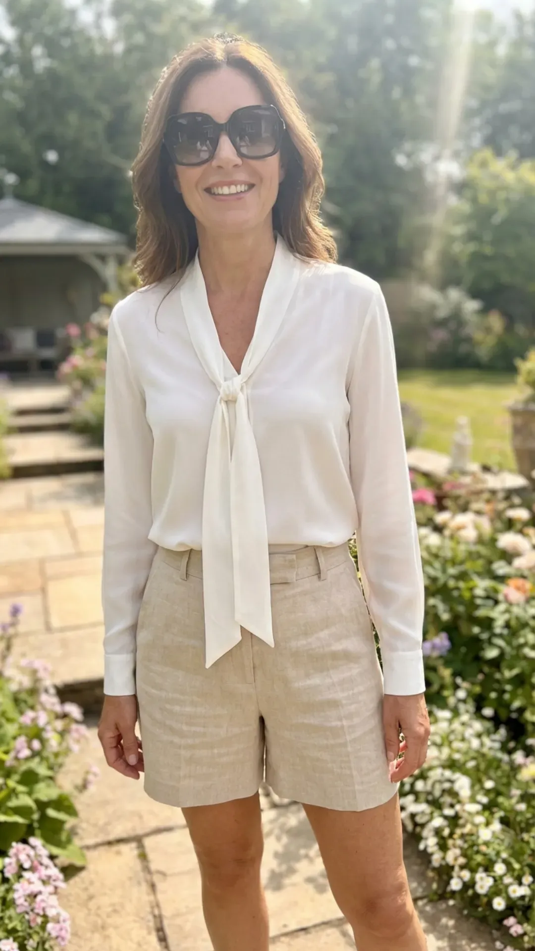 Pussy-bow blouse and tailored linen shorts for a chic warm-weather outfit