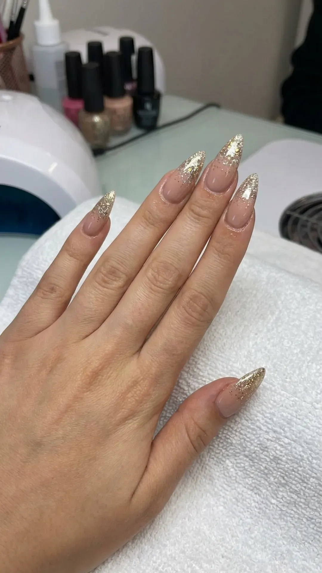Glitter fade ombre stiletto nails with sparkle concentrated at the tips