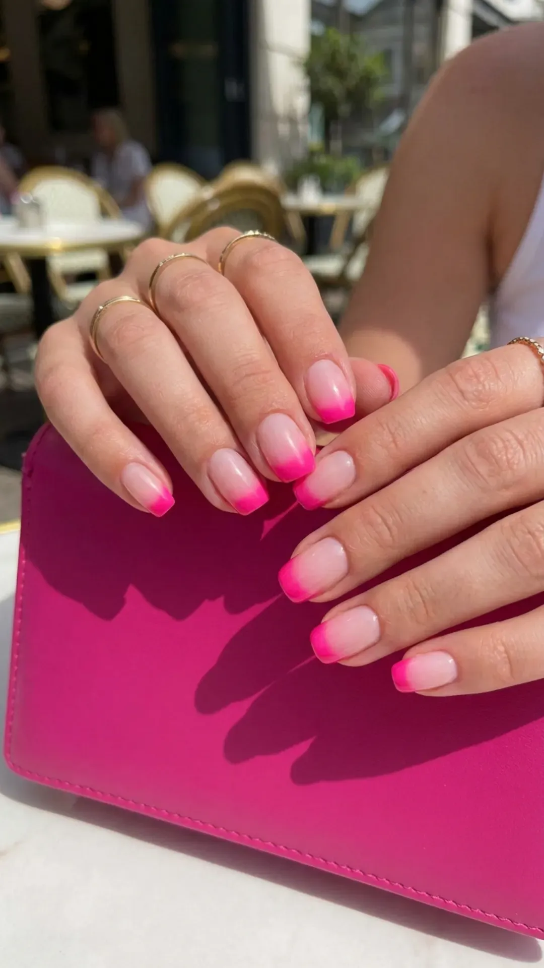 Vibrant short French tip nails featuring a bold transition from a natural pink base to vivid pink tips for a playful edge.
