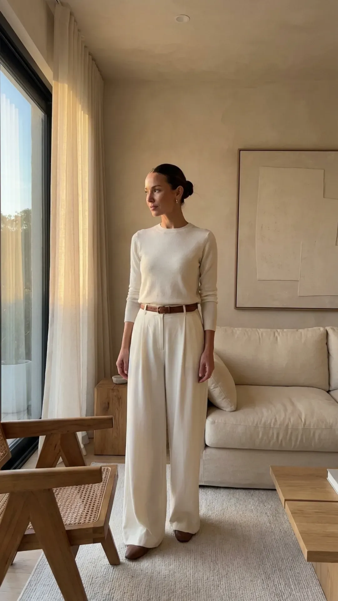 Monochromatic ivory outfit featuring tailored trousers and a knit sweater.