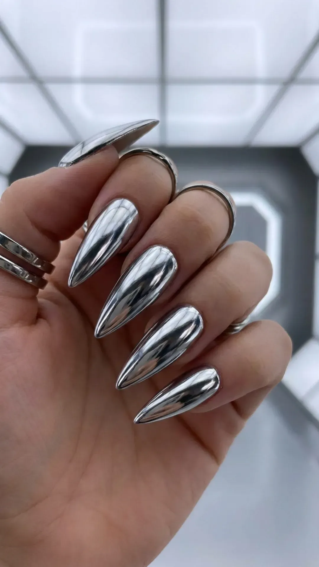 Silver chrome stiletto nails with a mirror-like shine