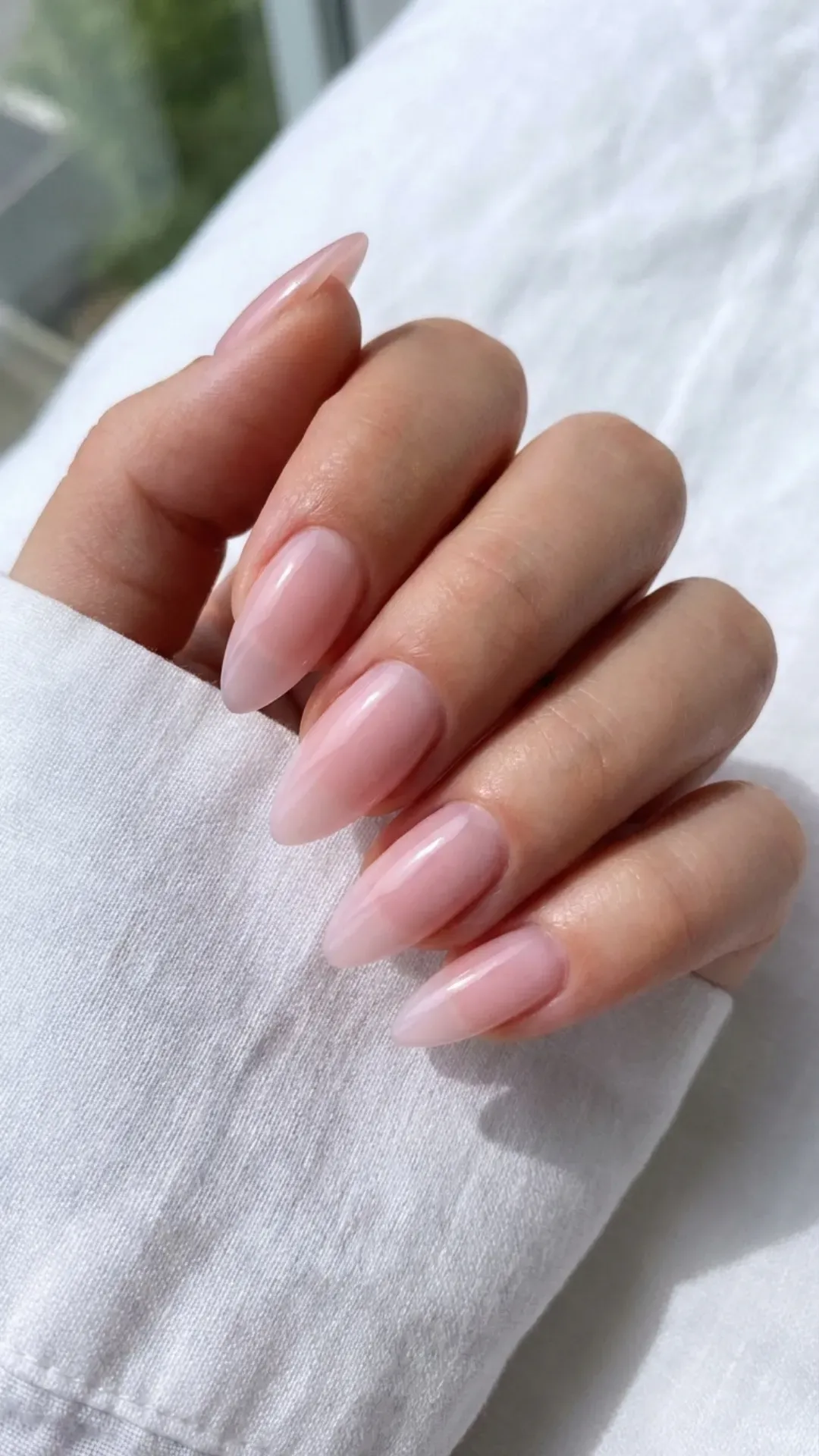 Sheer pink stiletto nails with a glossy clean girl finish