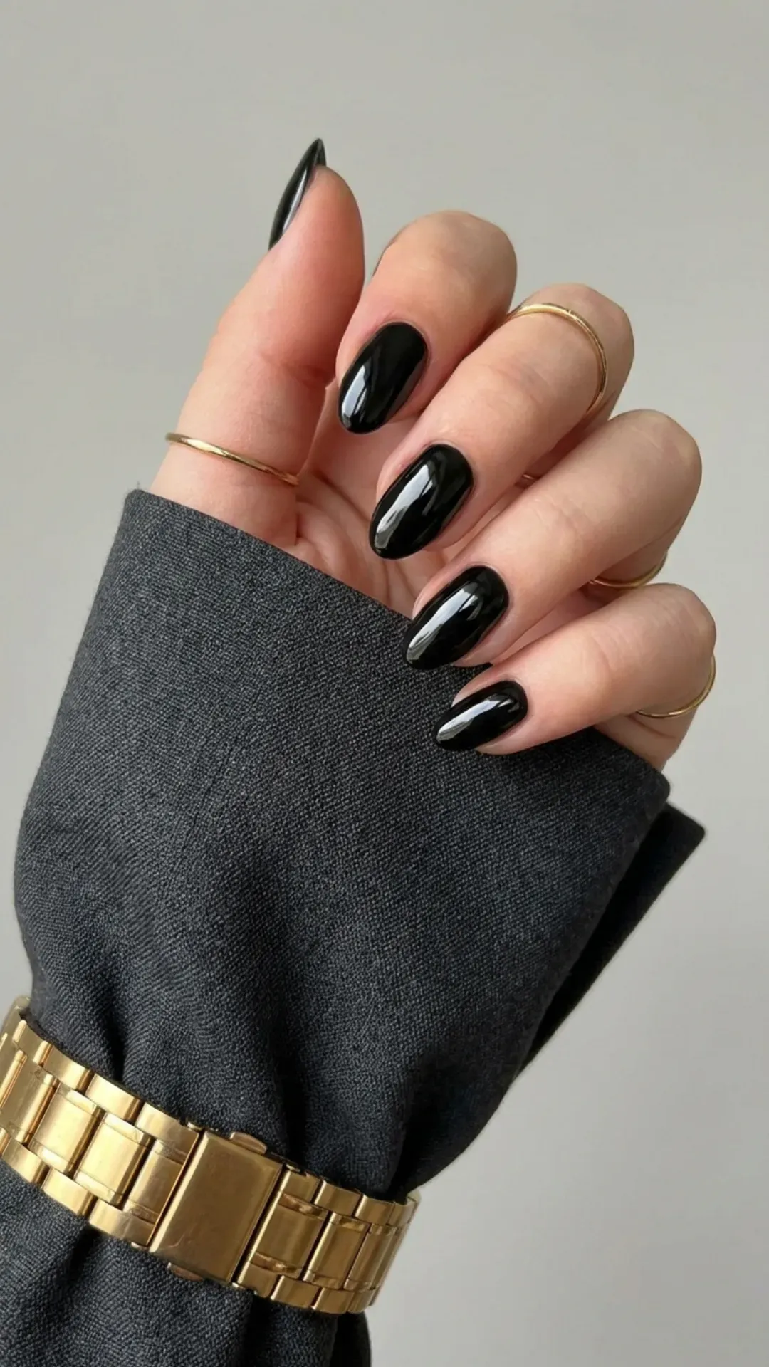 Sophisticated short almond-shaped nails painted in a sleek black polish, providing an elegant and slightly edgy nail style for everyday sophistication.