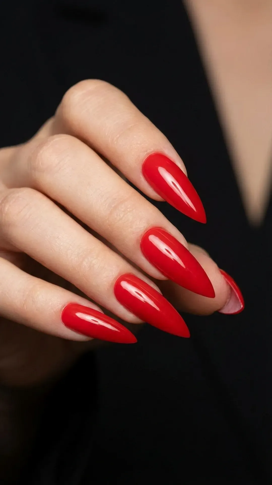 Glossy bright red stiletto nails with dramatic pointed shape