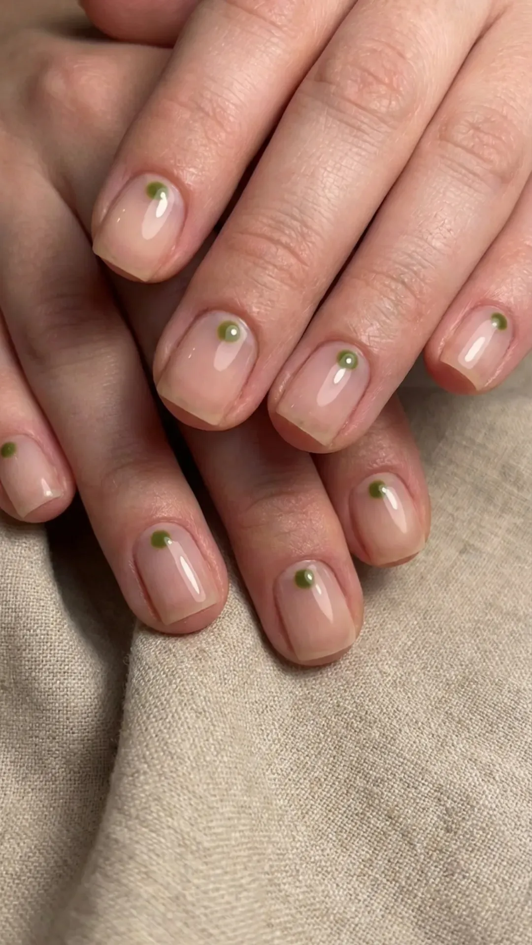 Sheer nails with a single minimalist olive green dot VANSWEG.COM