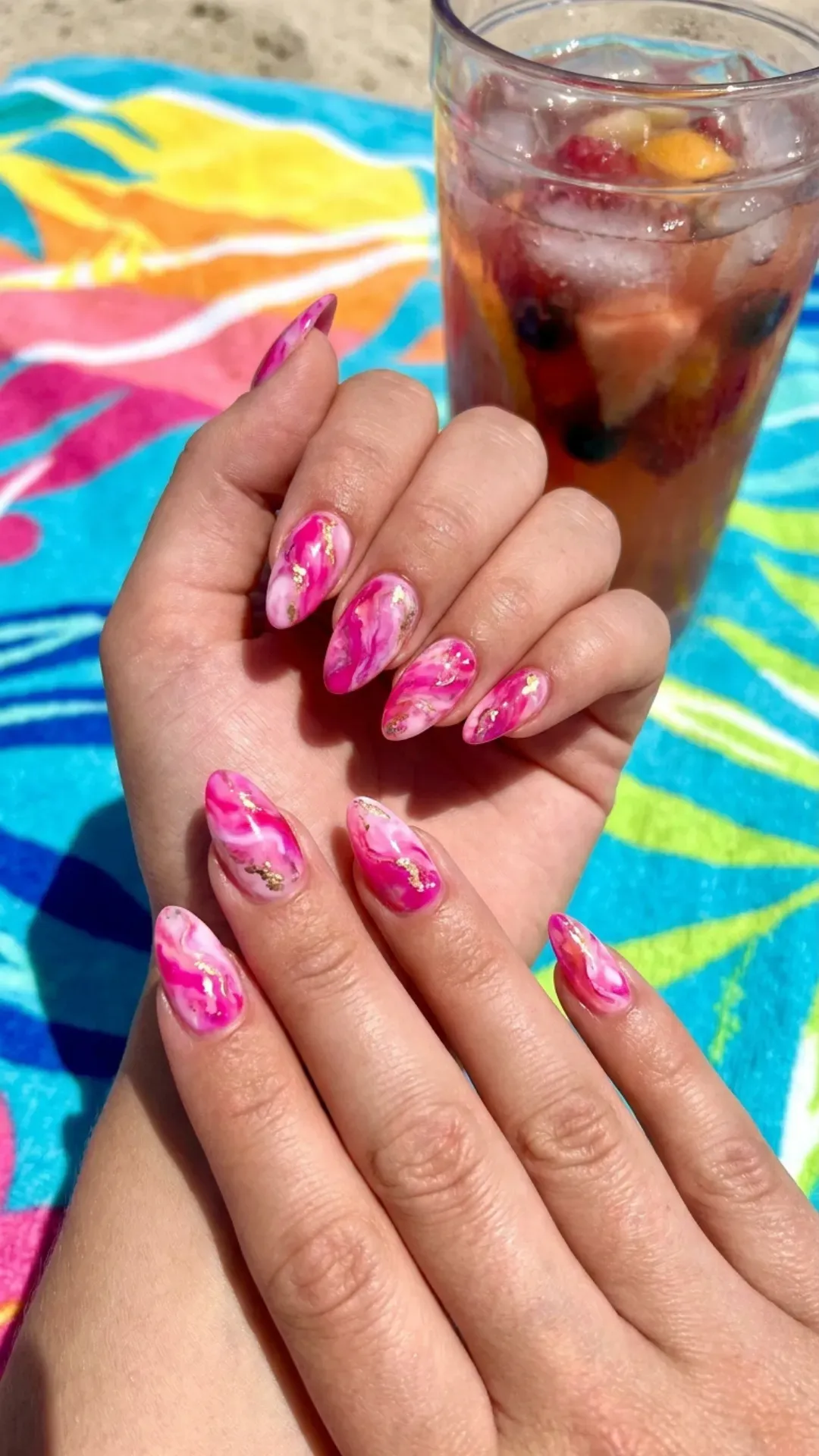 Vibrant pink marble nails with swirling patterns, ideal for a playful and eye-catching summertime manicure.