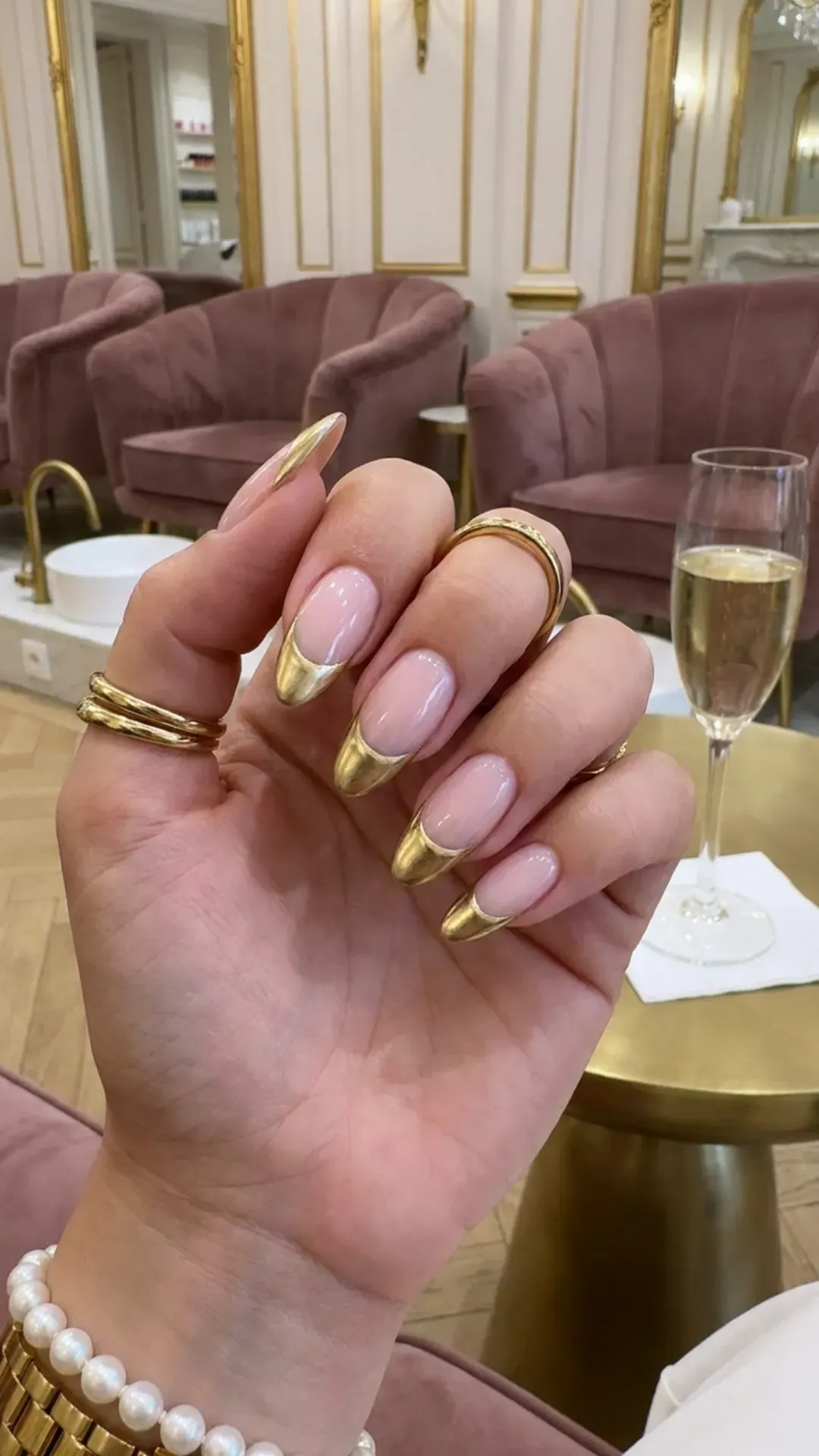 Luxurious French manicure with a translucent pink base and a gold crescent on the tips, merging elegance with a modern twist.