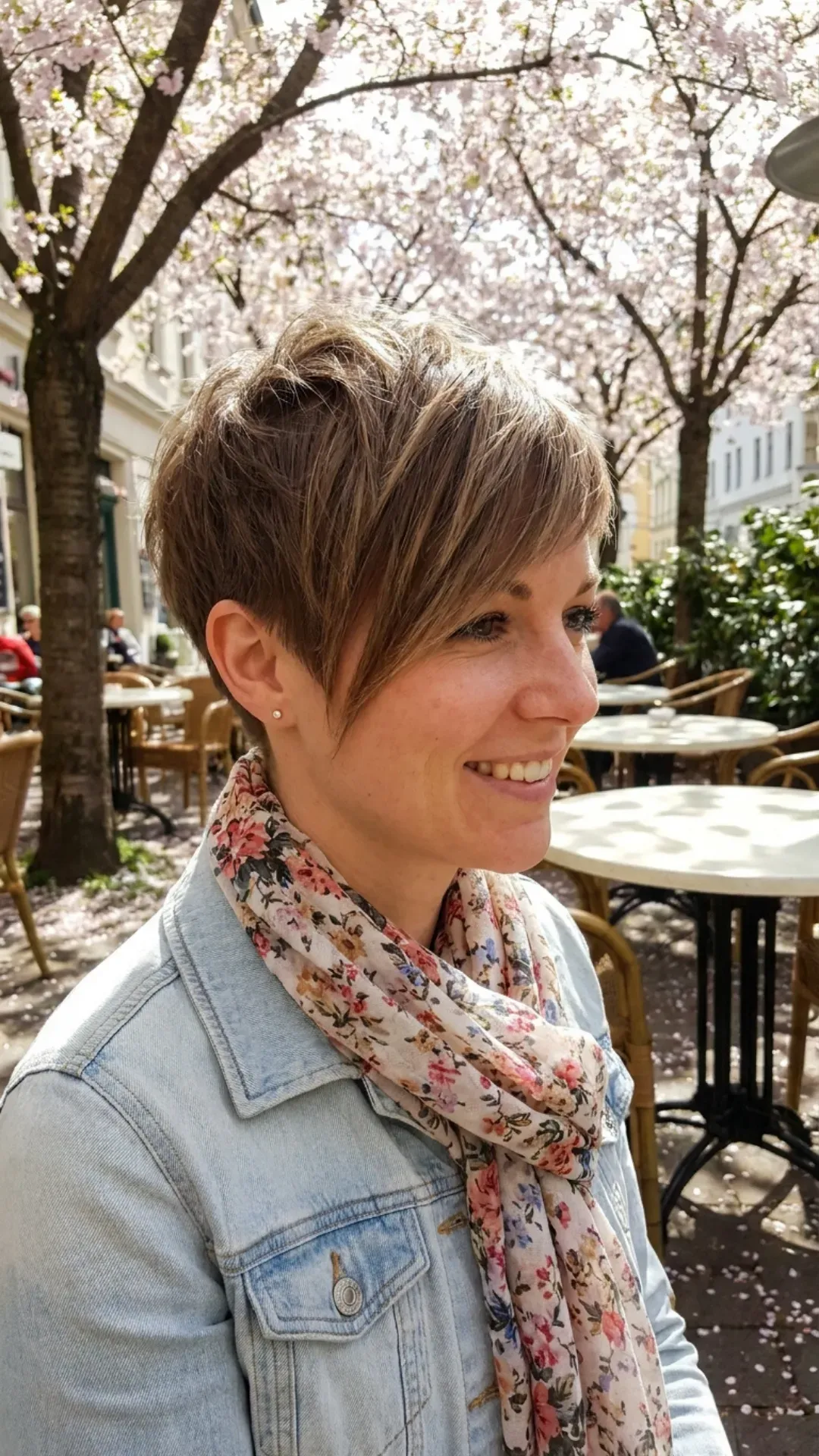 Trendy pixie cut with side-swept long bangs, offering a refreshing and low-maintenance hairstyle that highlights the facial features for spring.