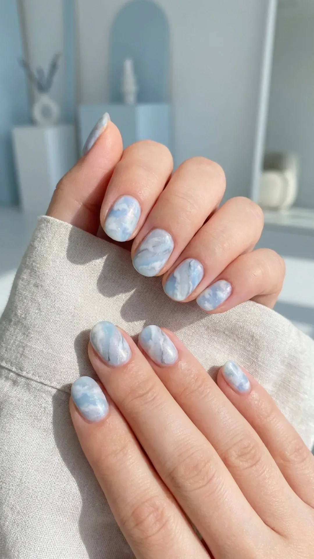 Soft and serene cloudy sky blue marble nails, creating a tranquil and airy nail art aesthetic.