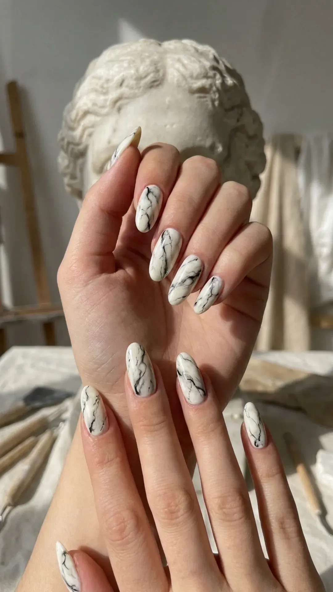 Timeless white marble nail art with intricate black veining, reminiscent of classic marble statues.