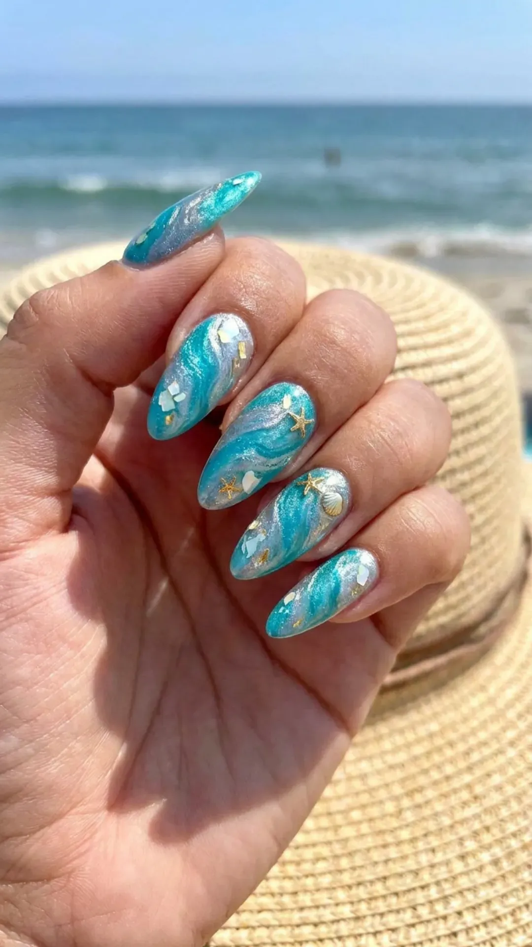 Vibrant turquoise and silver marble nails with a hint of marine inspiration, great for a bold summer look.