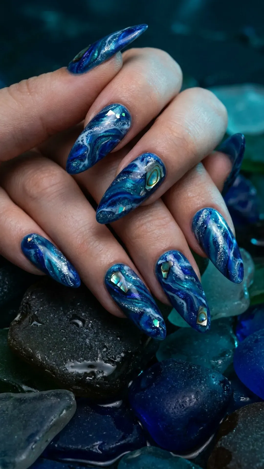 Deep blue swirling marble effect nails, evoking the mysterious depths of the ocean.