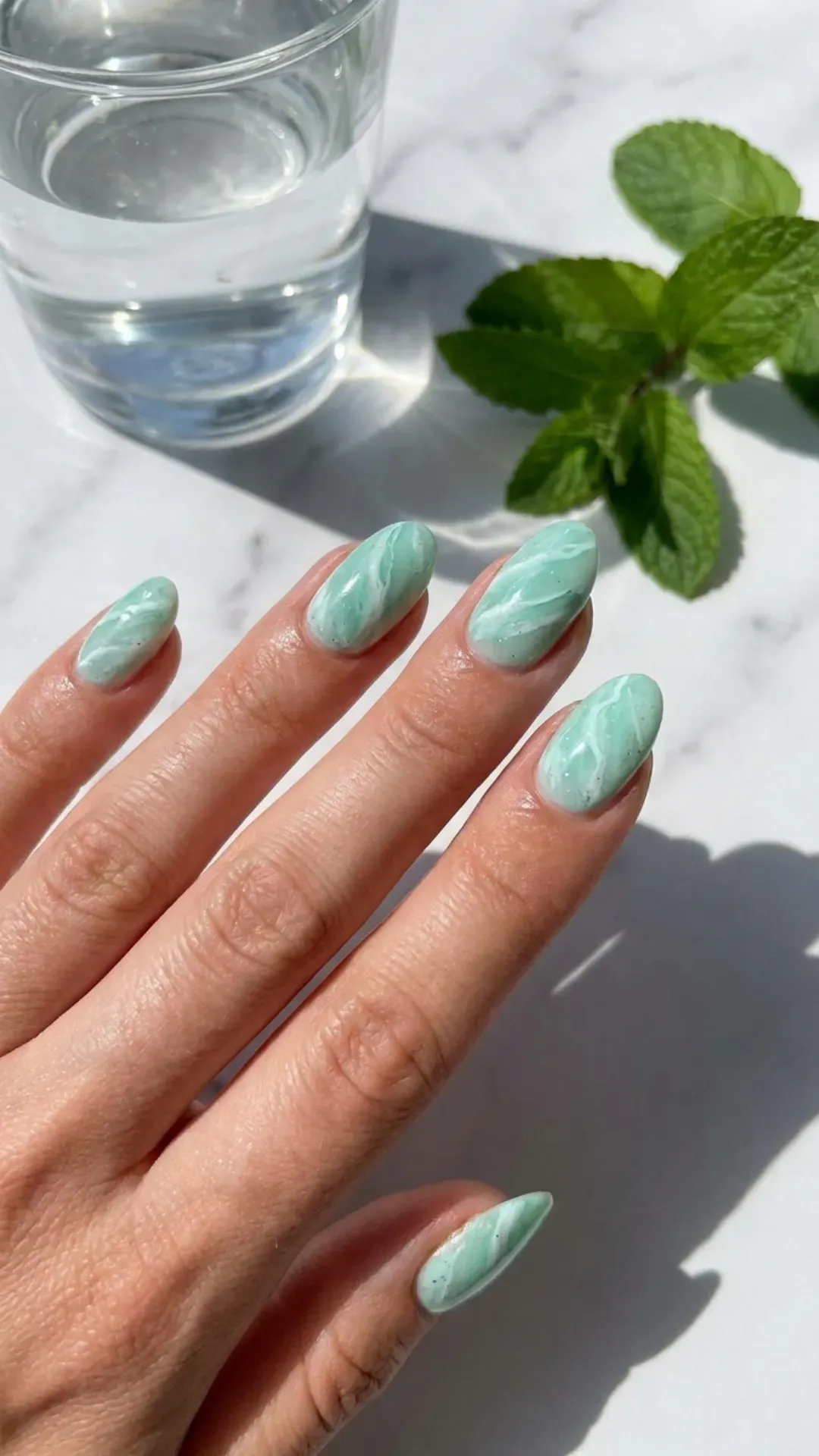 Refreshing mint green marble nails with subtle white accents, offering a fresh and clean look.