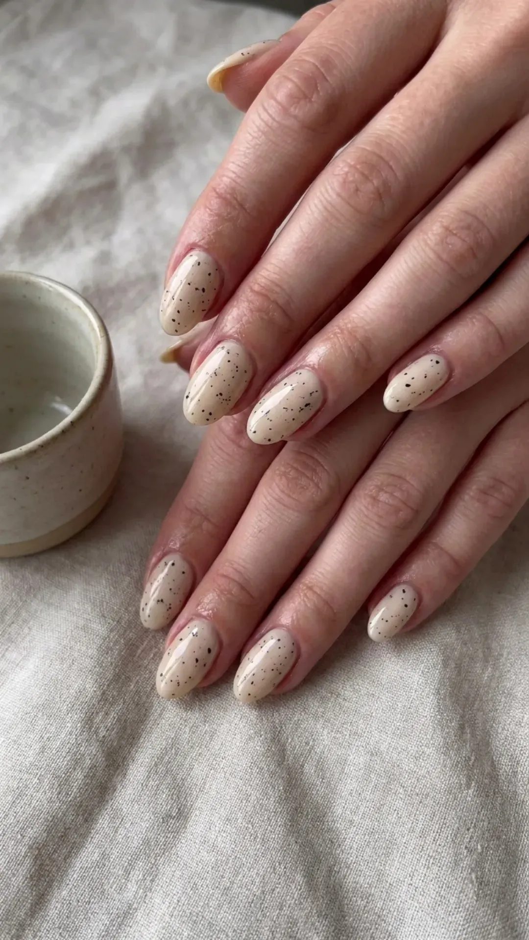 Neutral Speckled Nails with Oval Tips - Light beige nails with subtle black speckles and glossy finish
