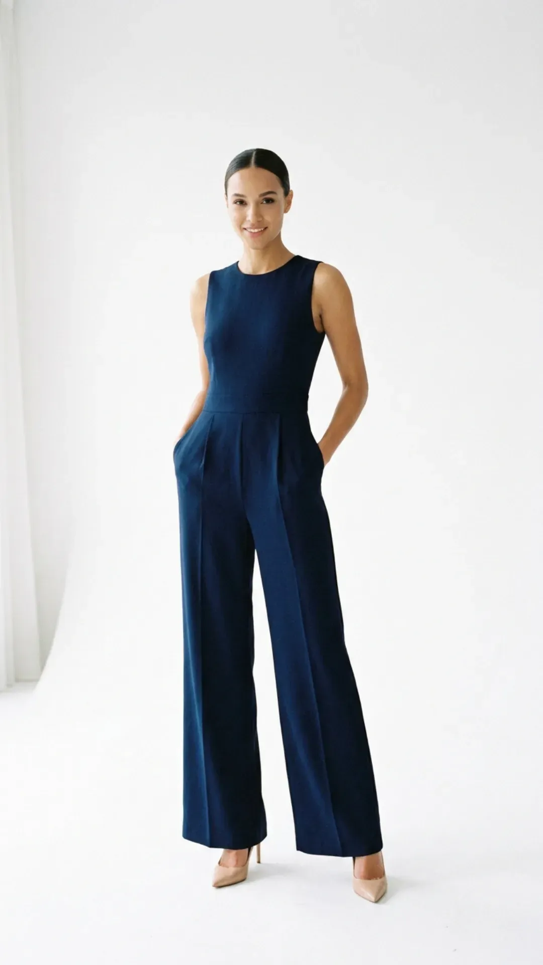 Navy blue wide-leg jumpsuit styled with pointed heels for a stylish outfit.
