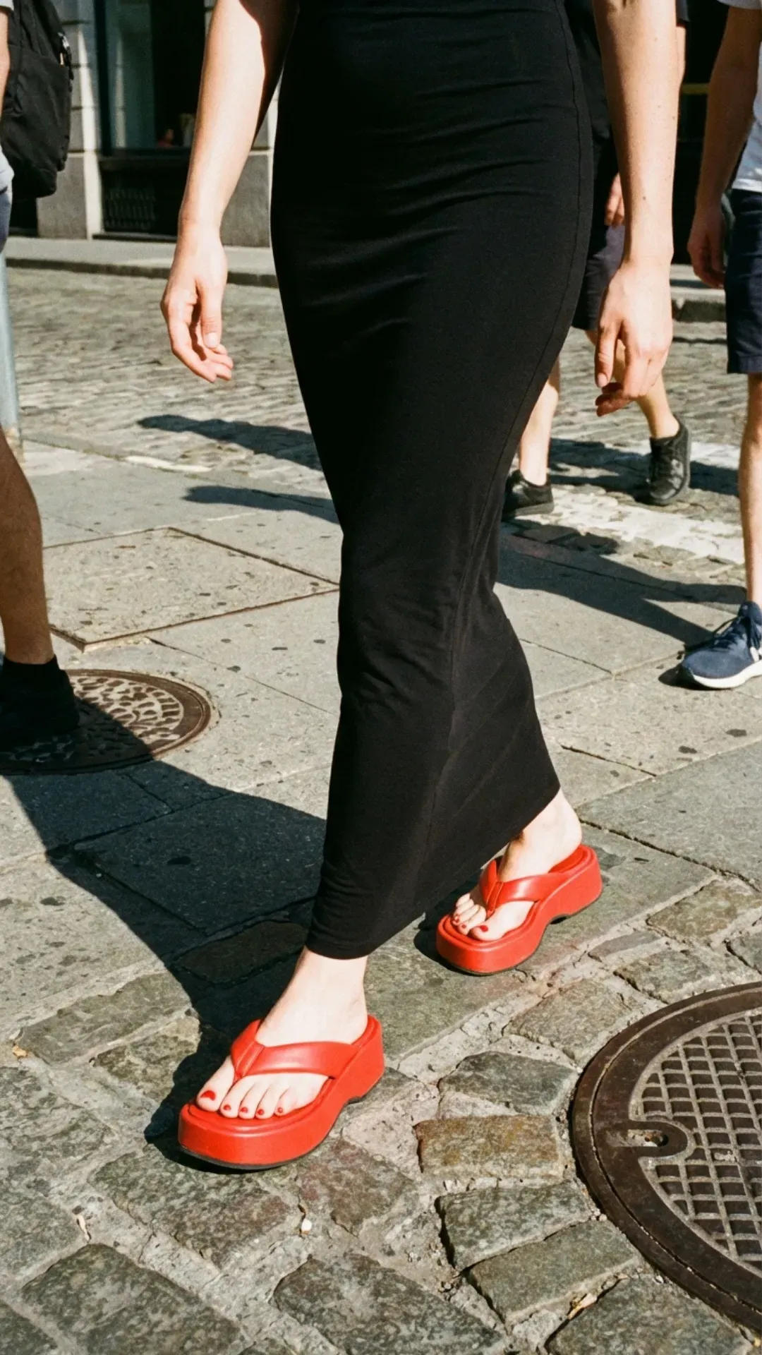 Black maxi dress paired with chunky platform flip-flops for a bold 2026 trend.