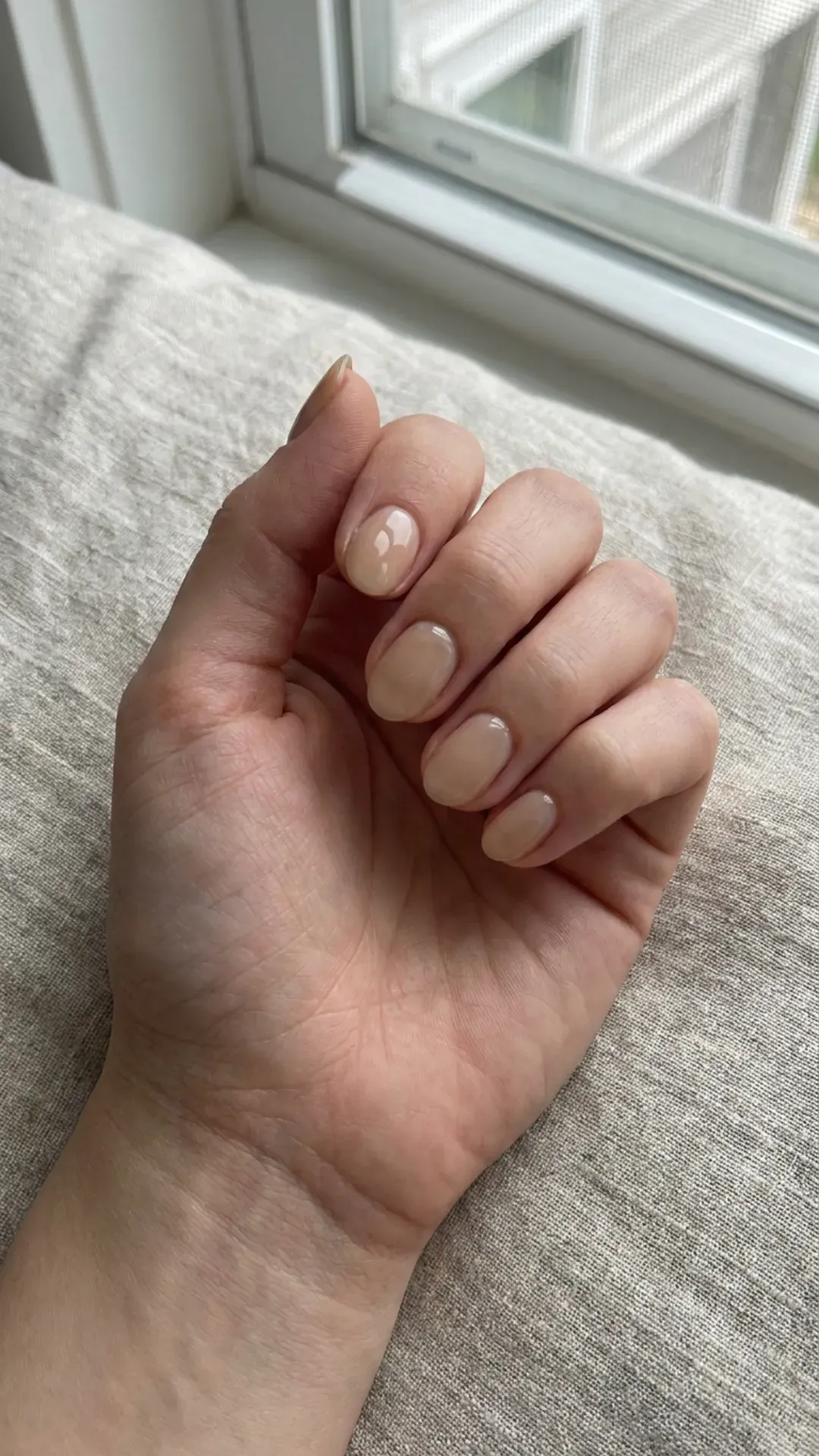 Natural Nude Nails in Soft Lighting - Clean nude polish on short oval nails with natural lighting