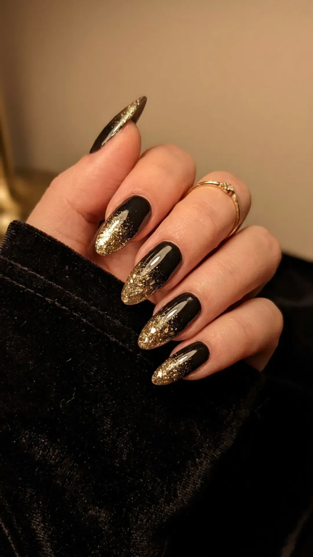 Elegant long nails with a gradient of black at the base transitioning to golden glitter at the tips, showcasing a luxurious and sparkling design.