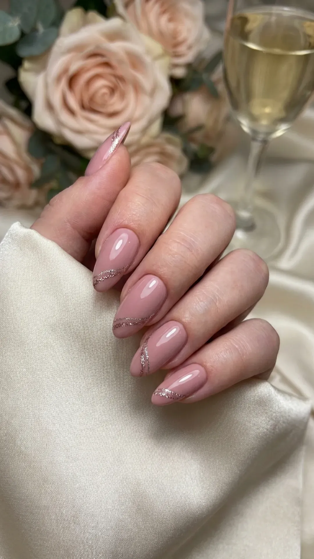 Elegant soft pink nails accented with thin lines of sparkling glitter creating a sophisticated and refined manicure