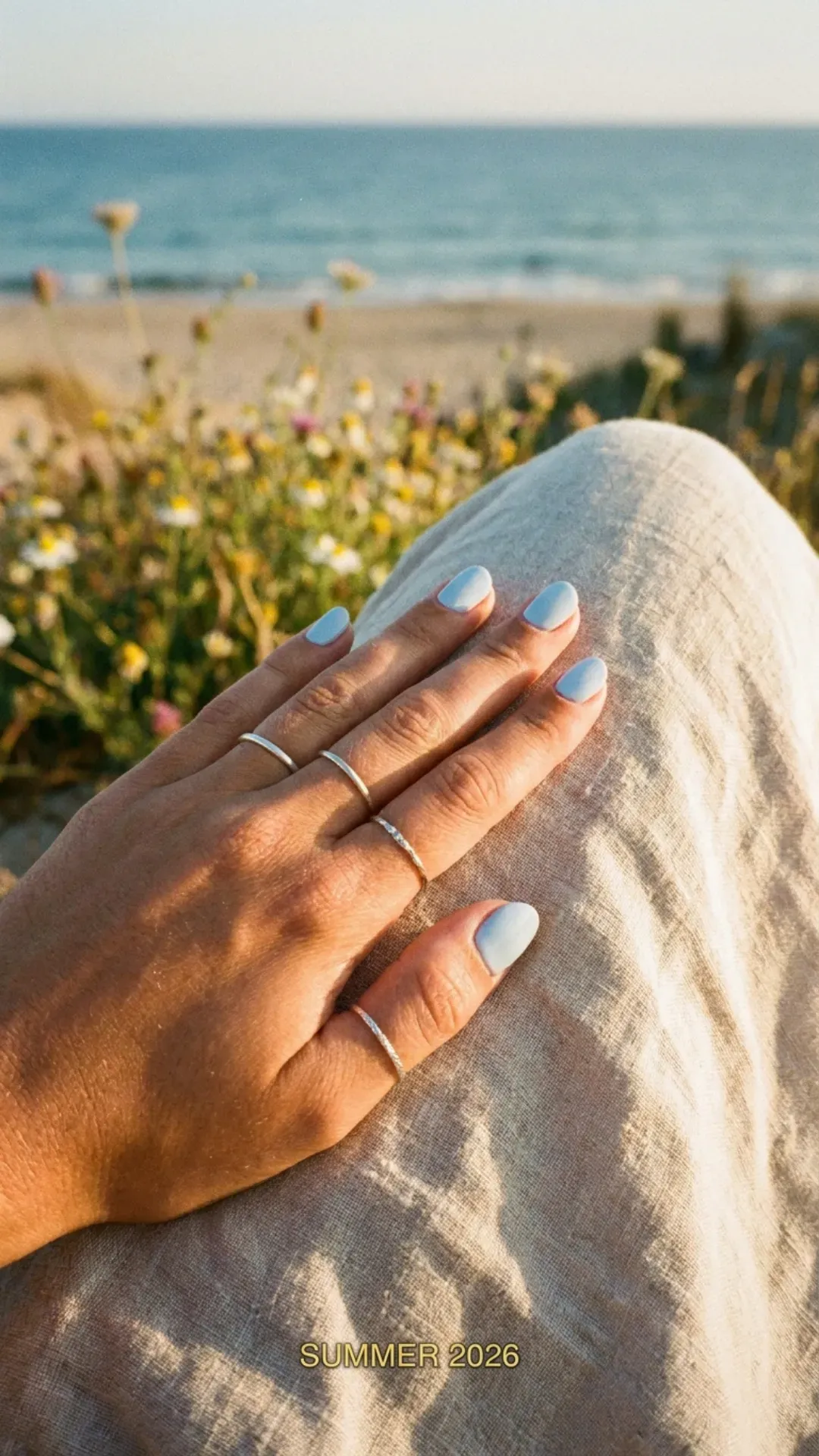 Hand with pastel blue nail polish, featuring a soft and calming color ideal for a summer day in 2026.
