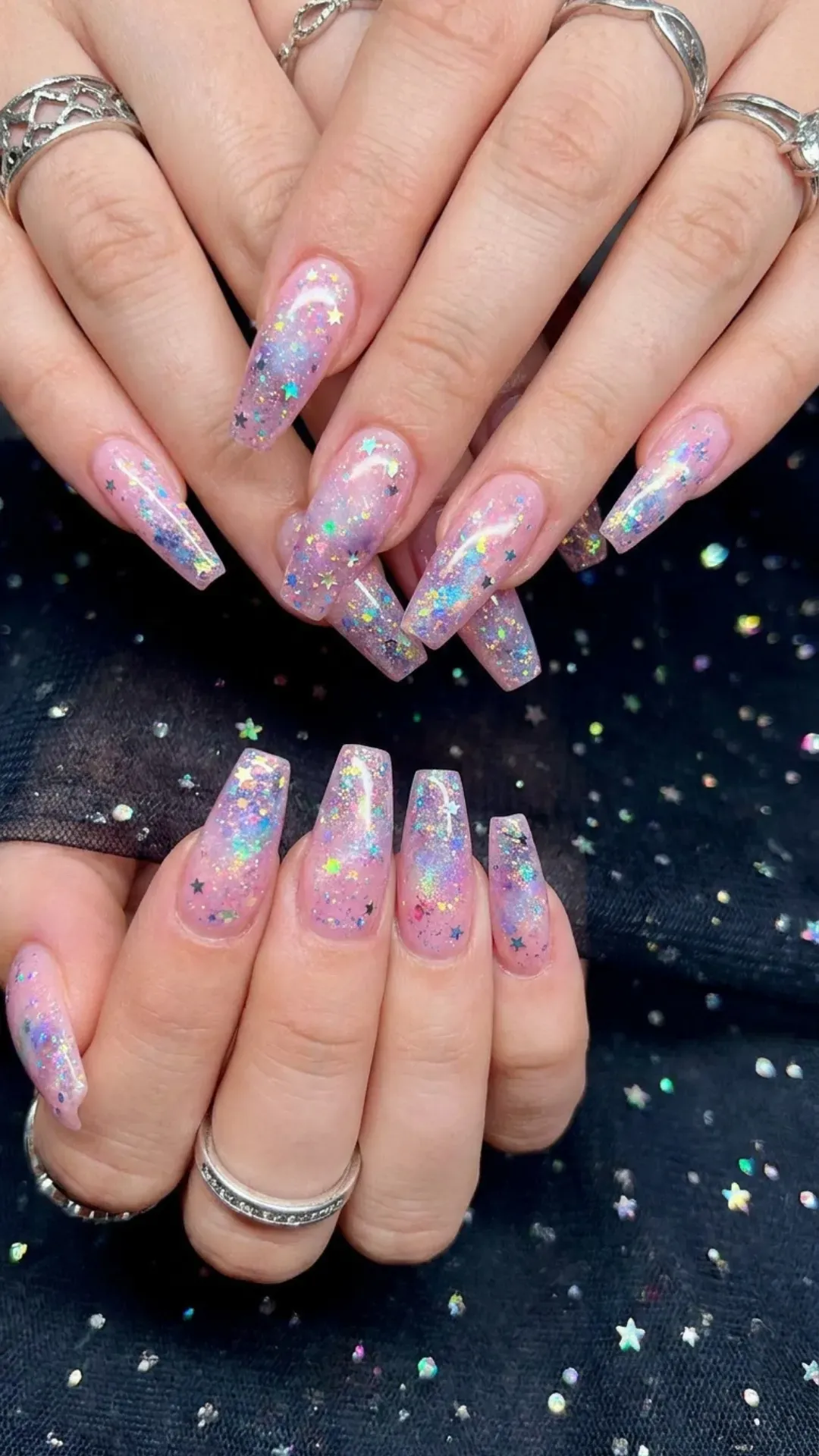 Coffin nails with a pink base speckled with glitter, resembling a starry galaxy, adding a touch of cosmic wonder and sparkle.