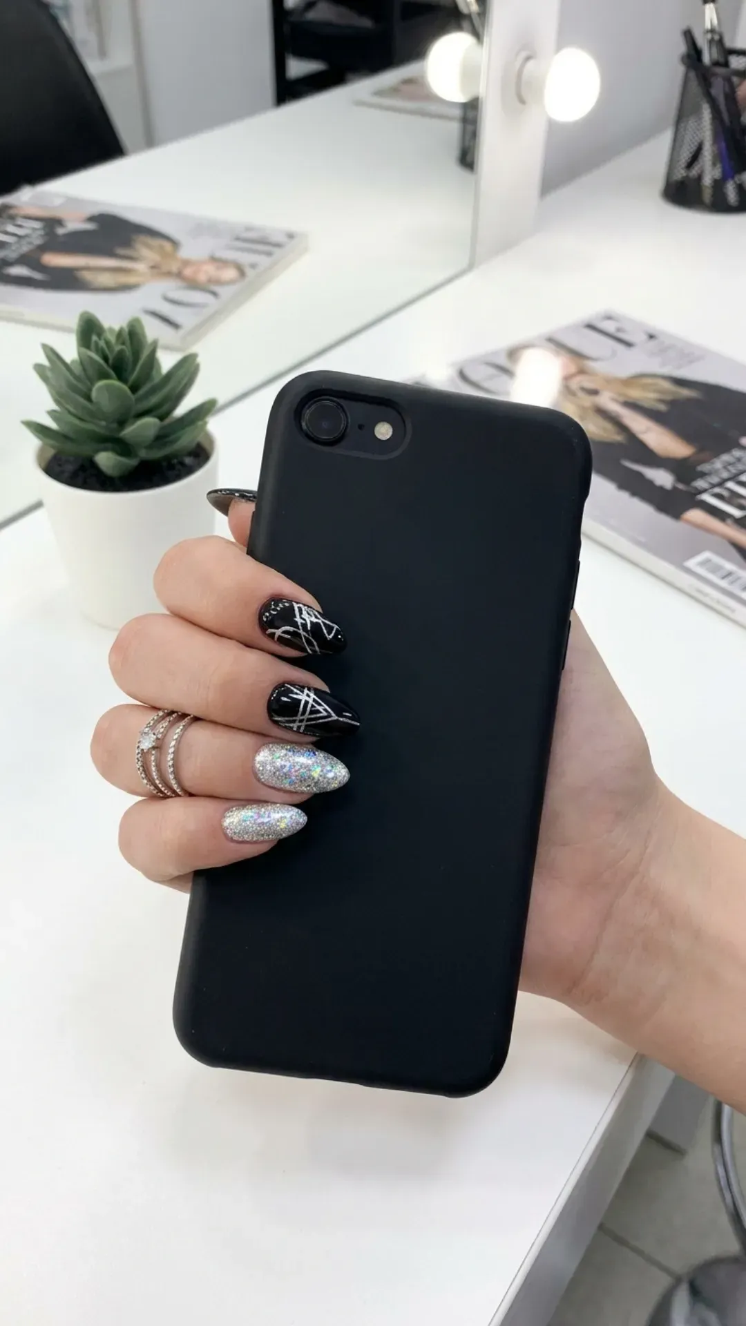  Bold and stylish nails alternating in glossy black and silver glitter, with a creative mix of patterns for a modern and fashionable look.