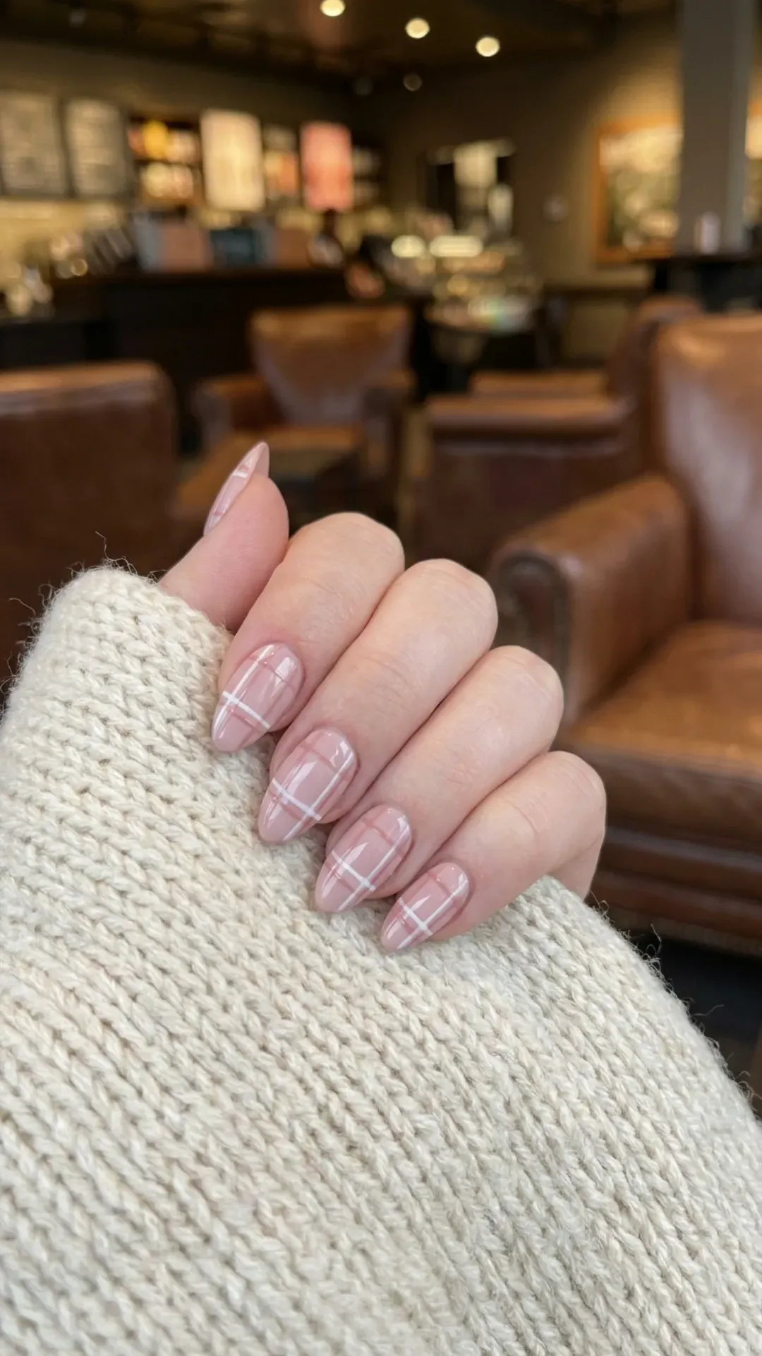 Soft pink nails with delicate white and pink plaid patterns, creating a classic yet modern look that mimics a warm and stylish winter scarf, tailored for a sophisticated winter fashion statement.